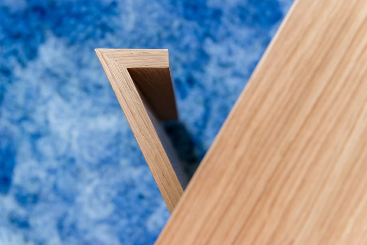 Détail d'un pied de bureau en bois sur tapis bleu