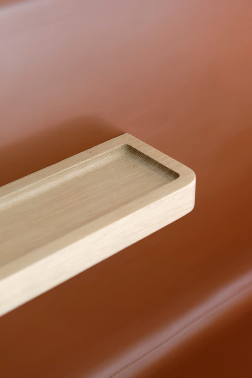 Détail d'une tablette en bois sur fond cuir terracotta