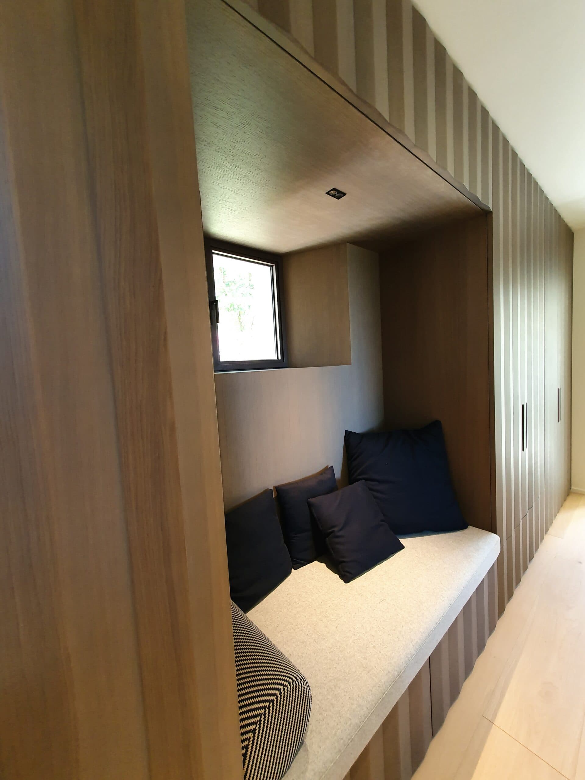 Niche de couchage en bois avec fenêtre et coussins