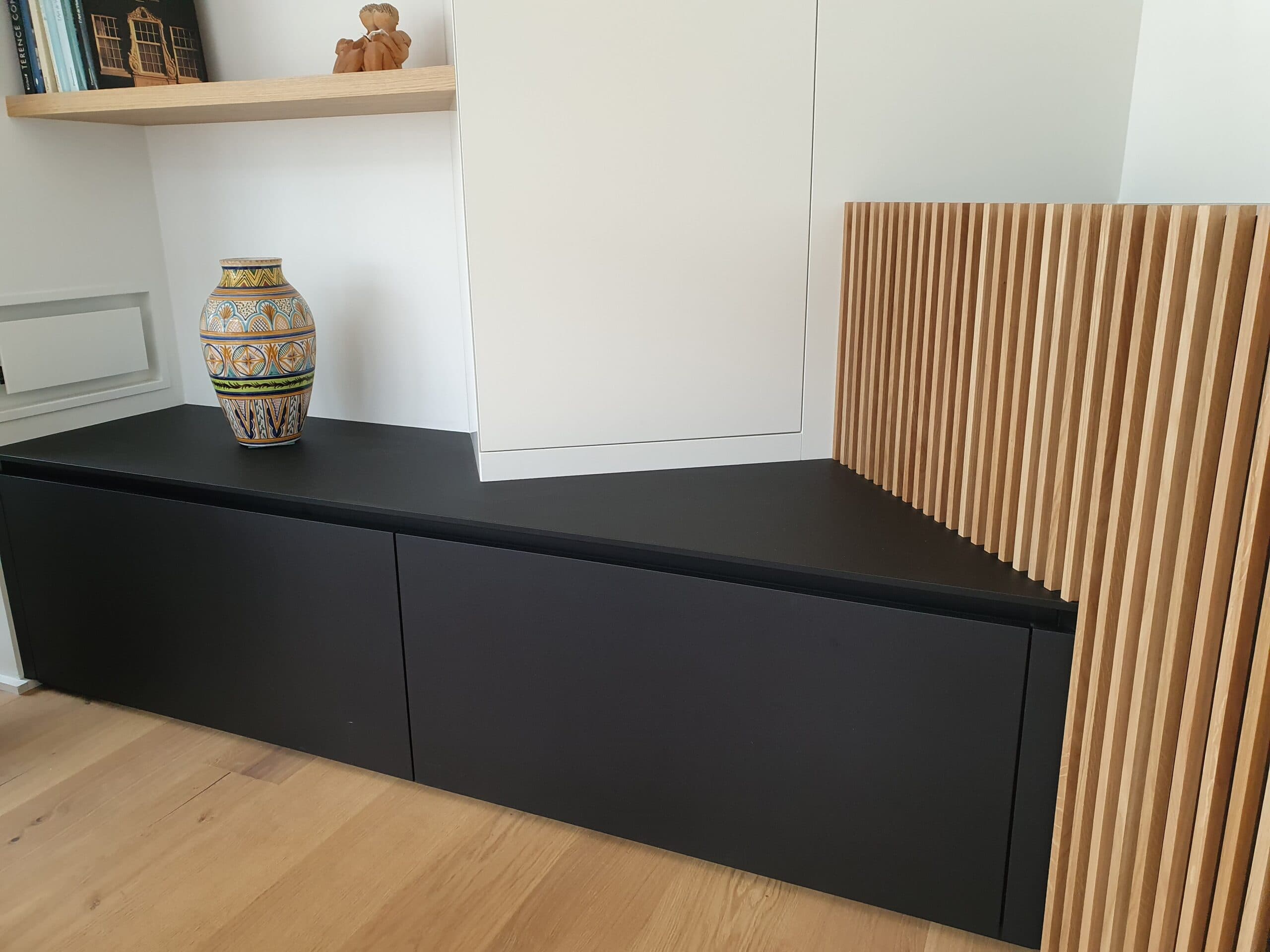 Banquette basse noire et claustra en lames de bois