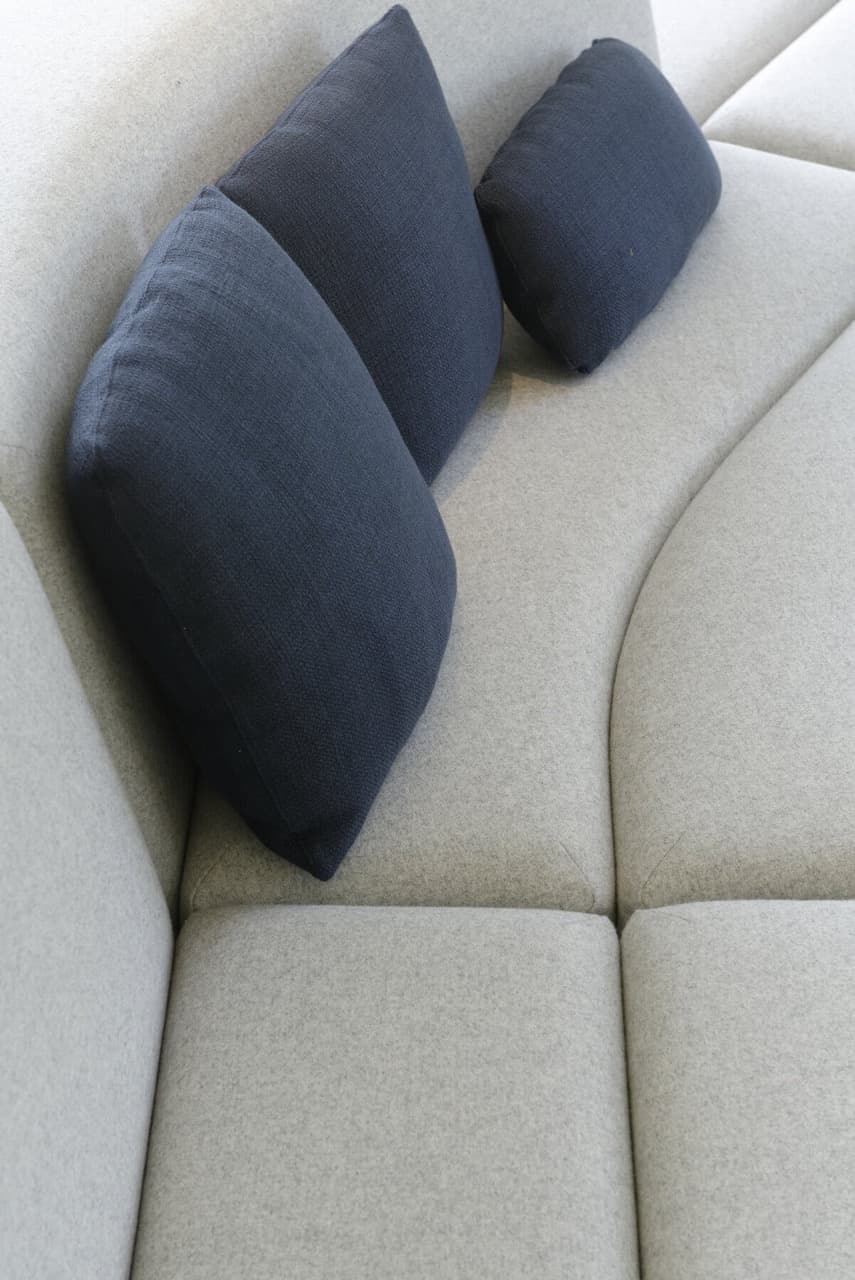 Banquette sur mesure en tissu clair avec coussins bleus