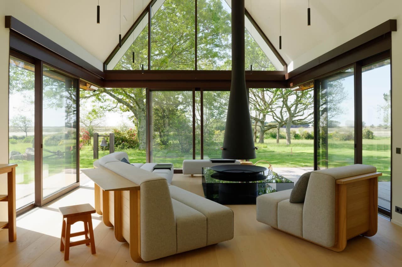 Salon avec banquettes sur mesure en bois et tissu face aux baies vitrées