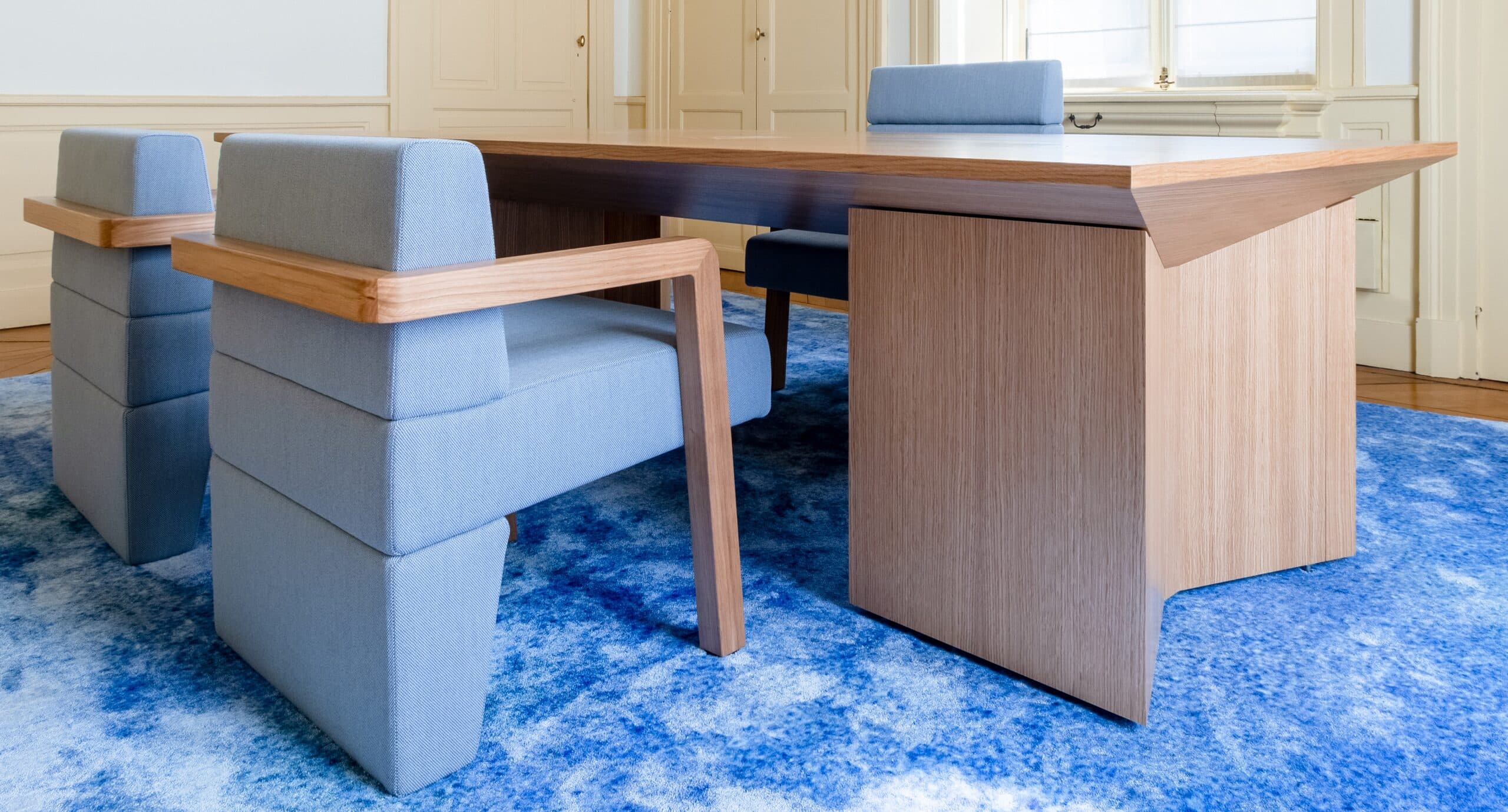 Bureau en bois et fauteuils bleus sur tapis bleu