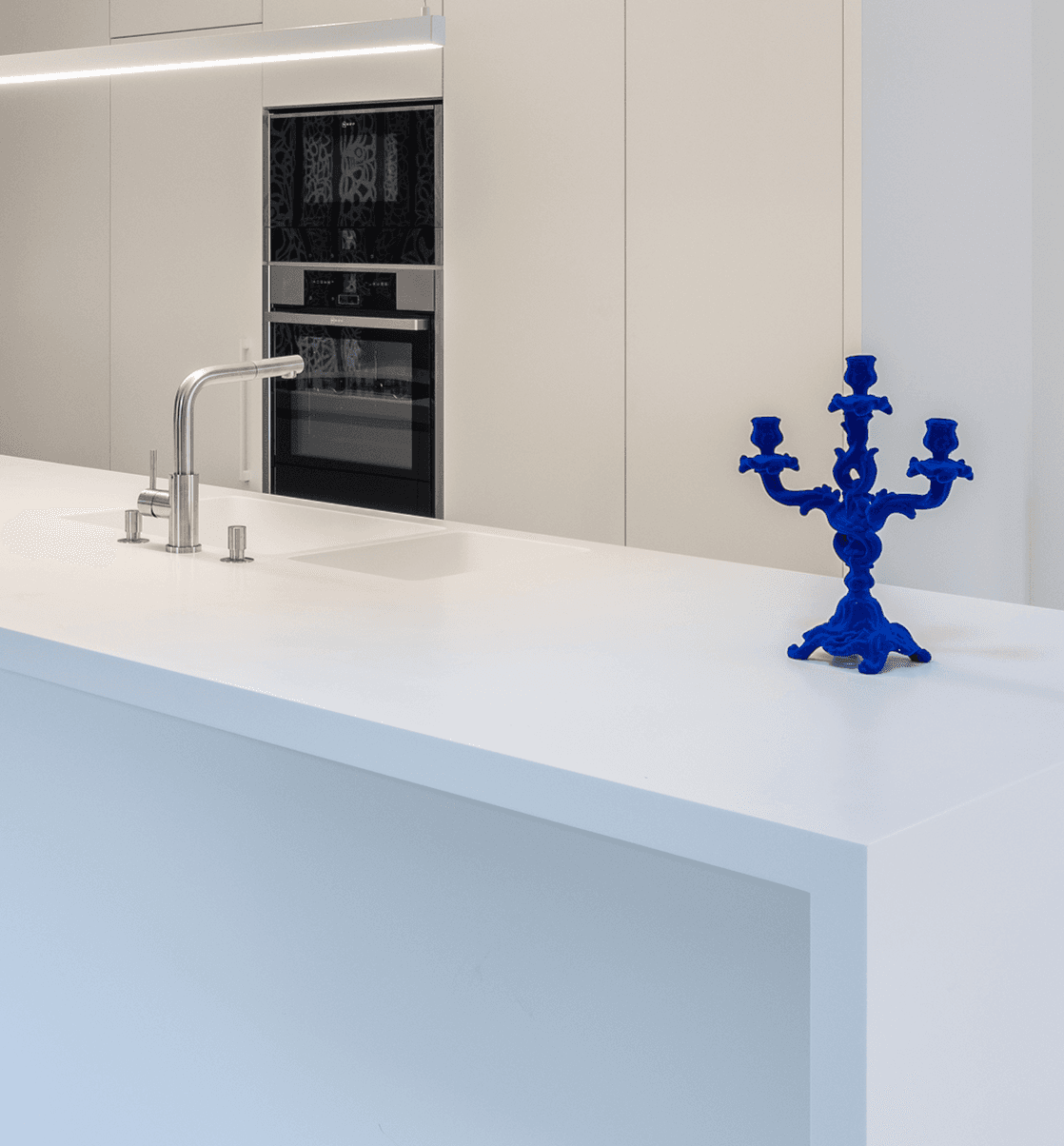 Îlot de cuisine blanc avec évier et colonne de fours