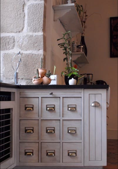 Meuble à tiroirs style apothicaire sous un plan de travail noir