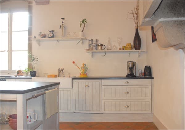 Cuisine blanche en bois peint avec évier sous fenêtre