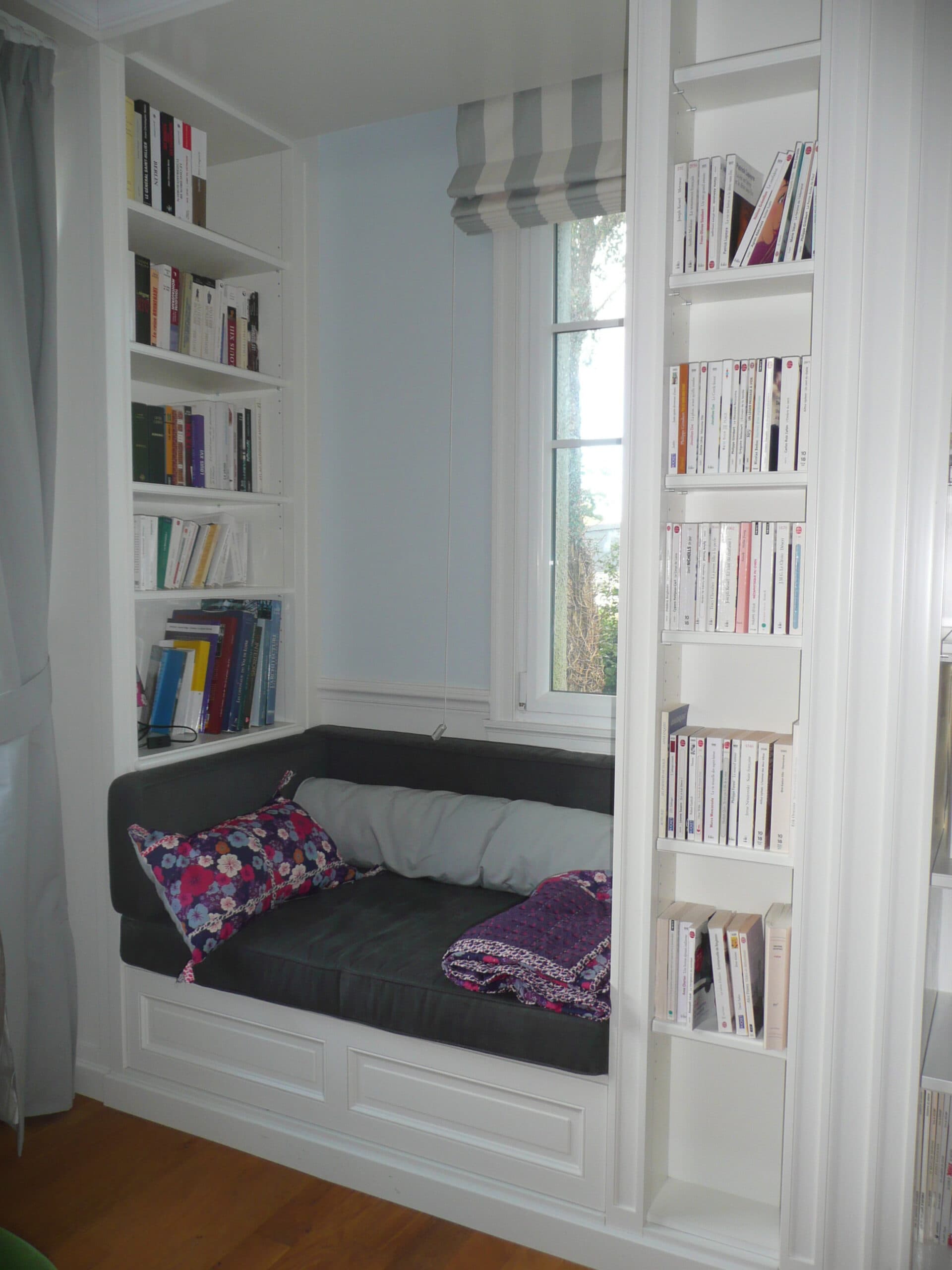 Banquette de lecture dans une niche entre deux bibliothèques