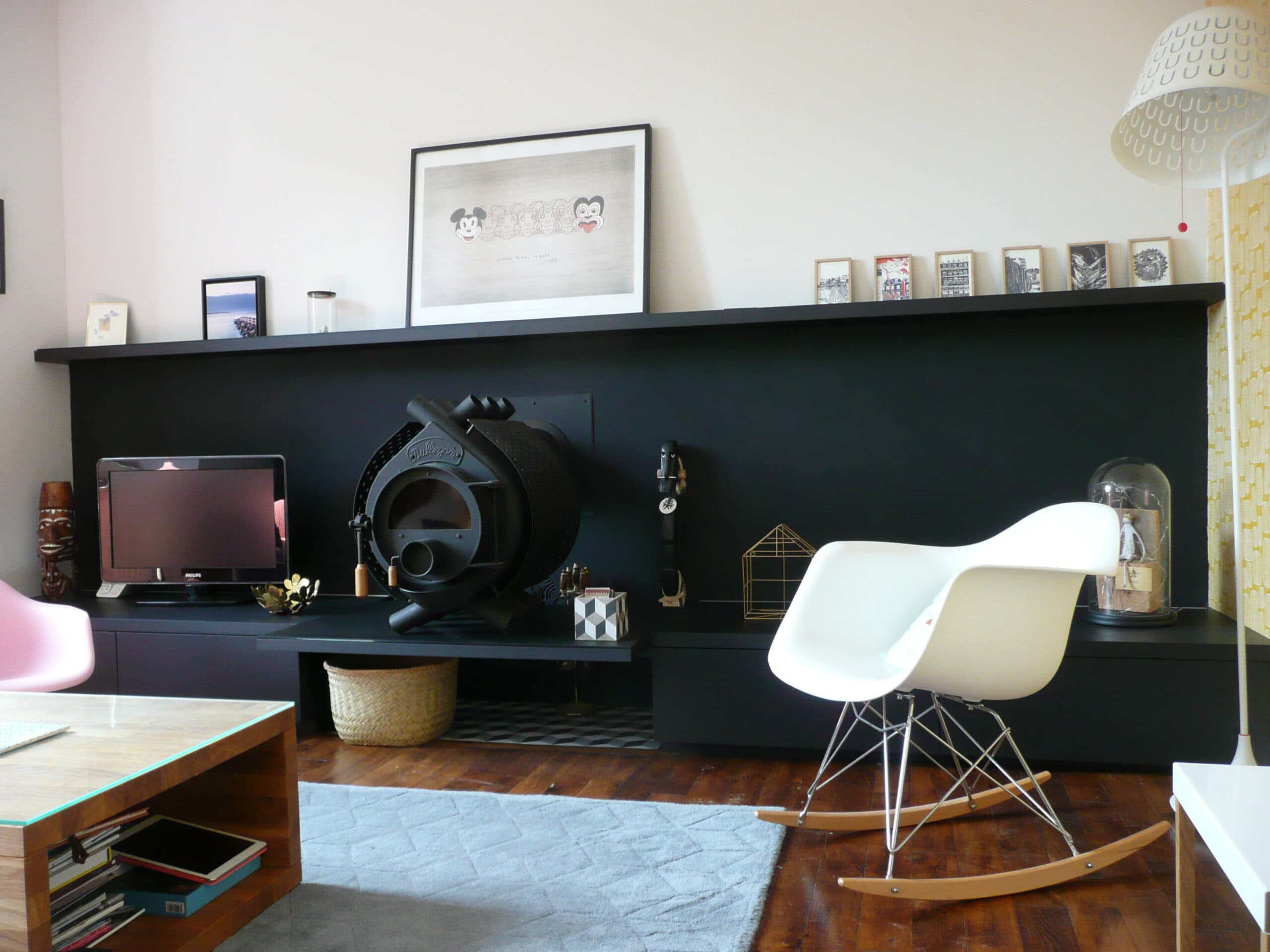 Meuble bas noir et étagère murale dans un salon
