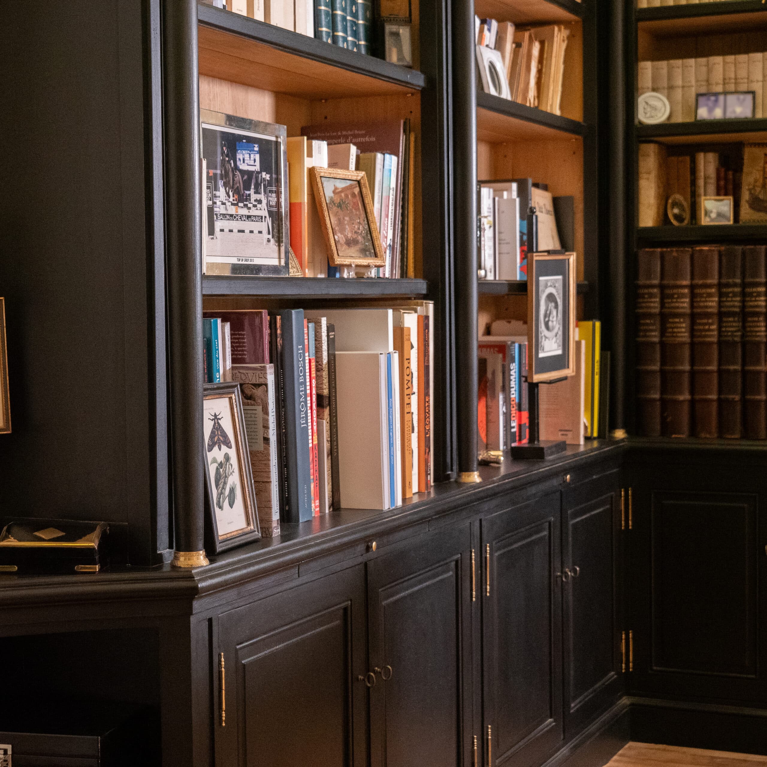 Bibliothèque sur mesure en bois foncé remplie de livres