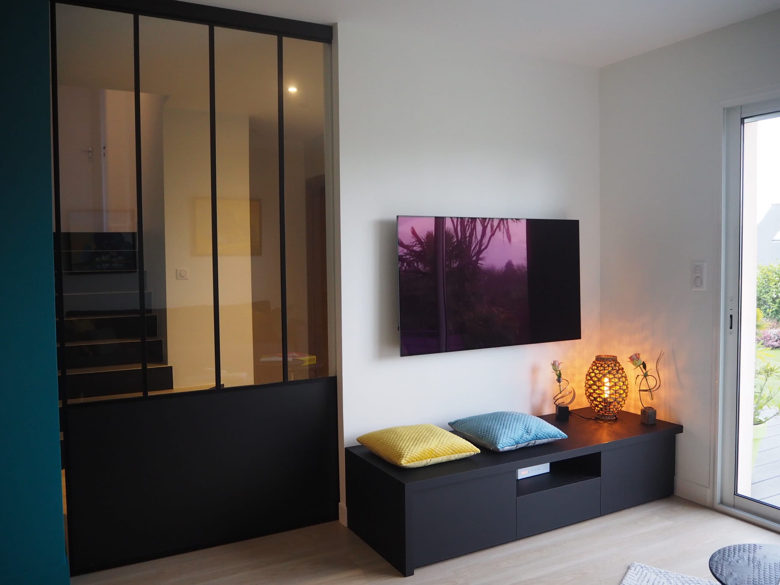 Meuble TV noir sous une verrière d'atelier
