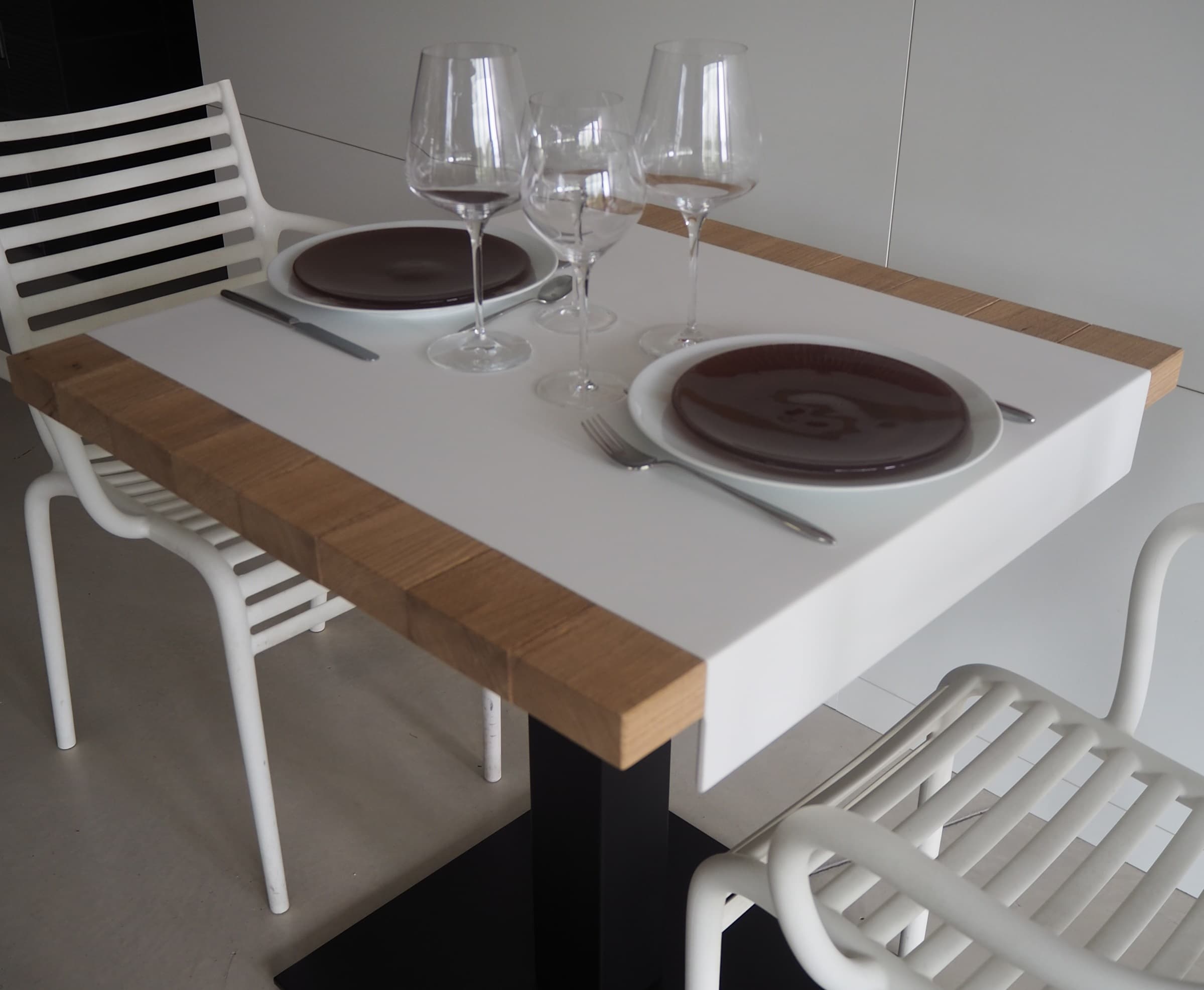 Table blanche avec chant en chêne et couverts dressés