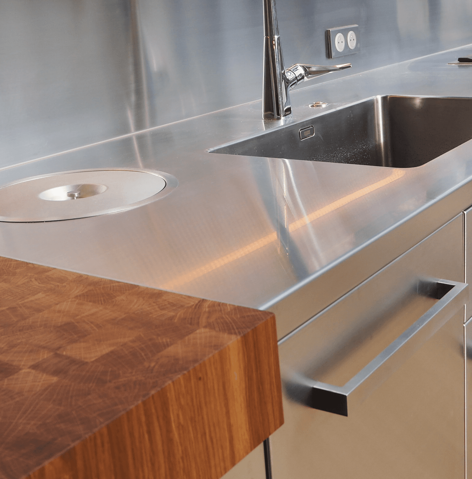 Détail d'un billot en bois sur un plan de travail inox