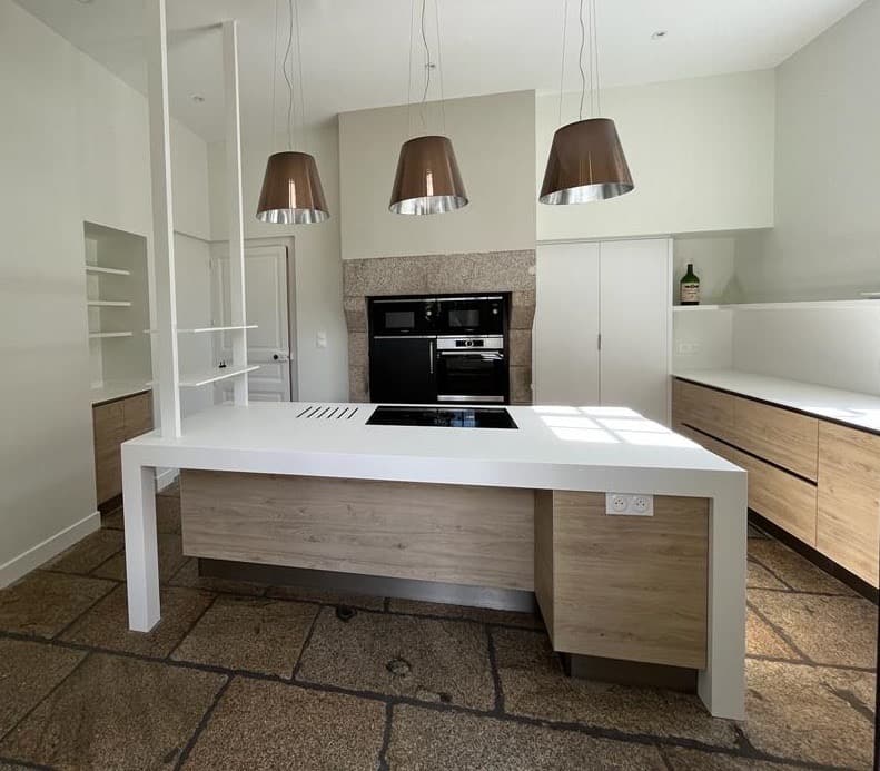 Îlot de cuisine blanc et bois sur sol en pierre