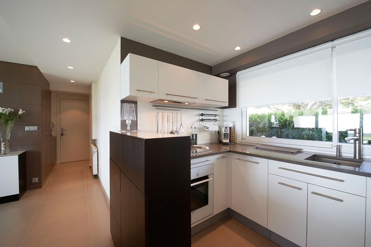 Cuisine blanche en L avec colonne en bois foncé