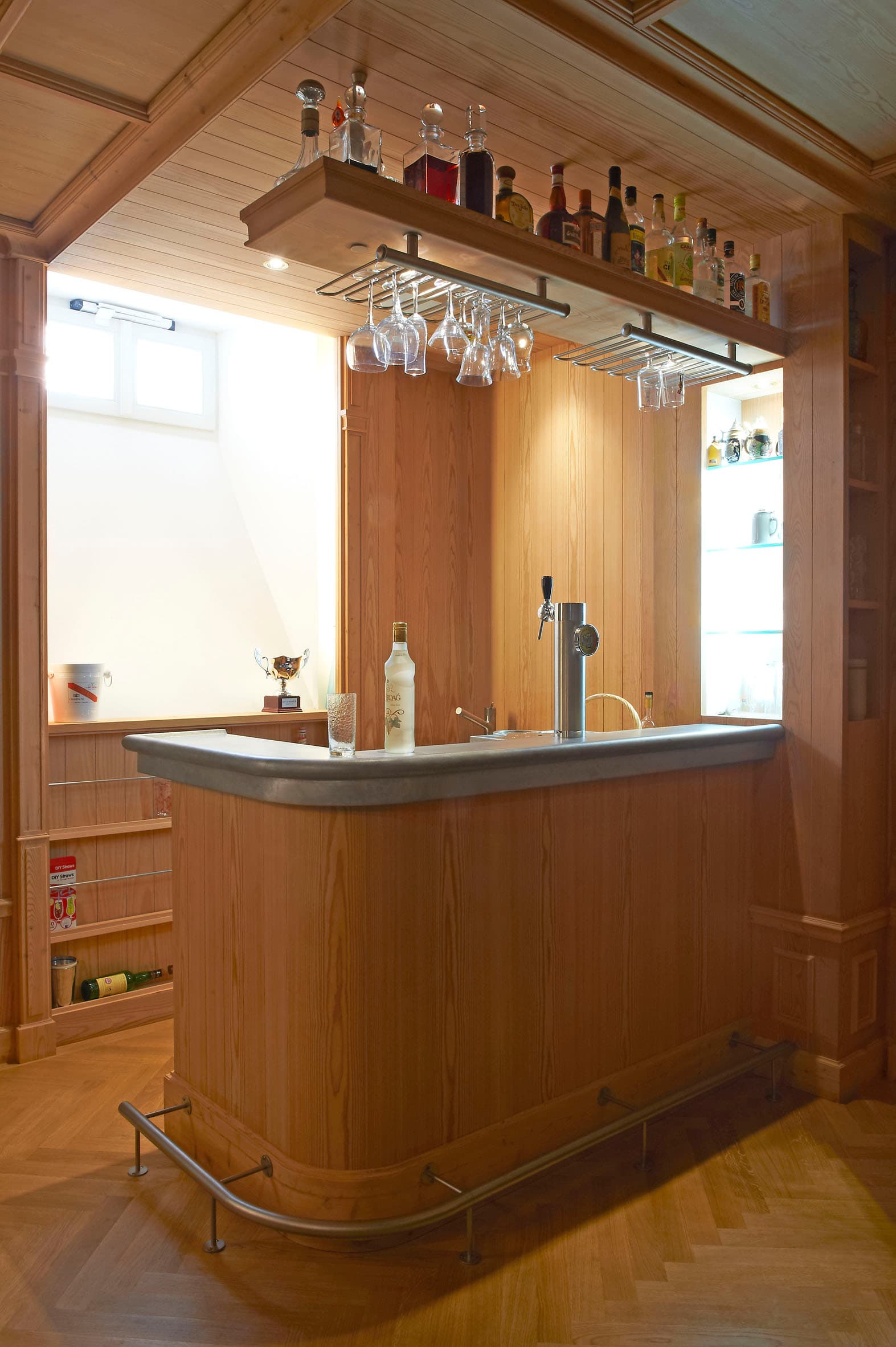 Bar en bois massif avec comptoir arrondi dans une salle de jeux