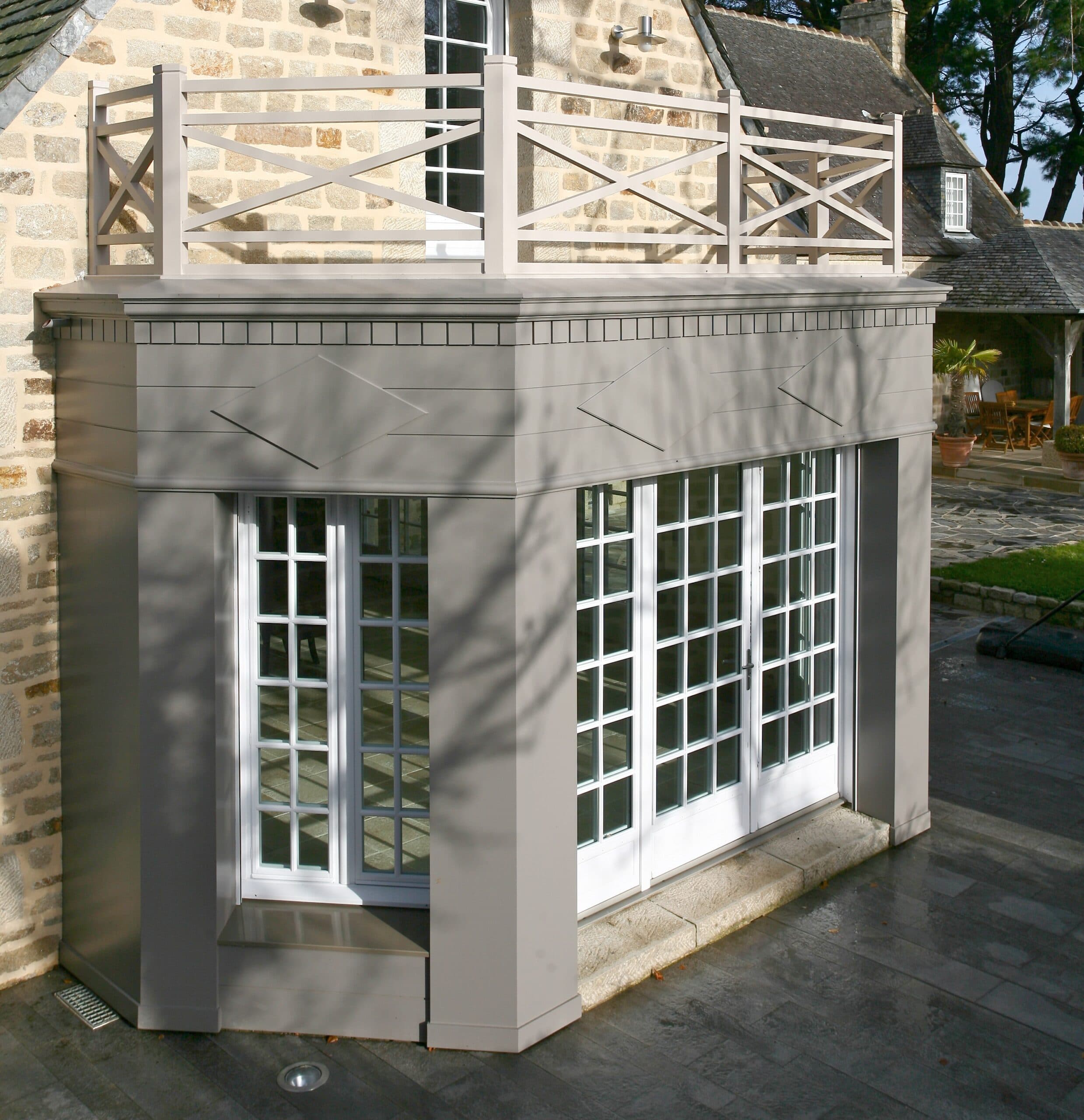 Extension avec grandes fenêtres à petits carreaux et balcon