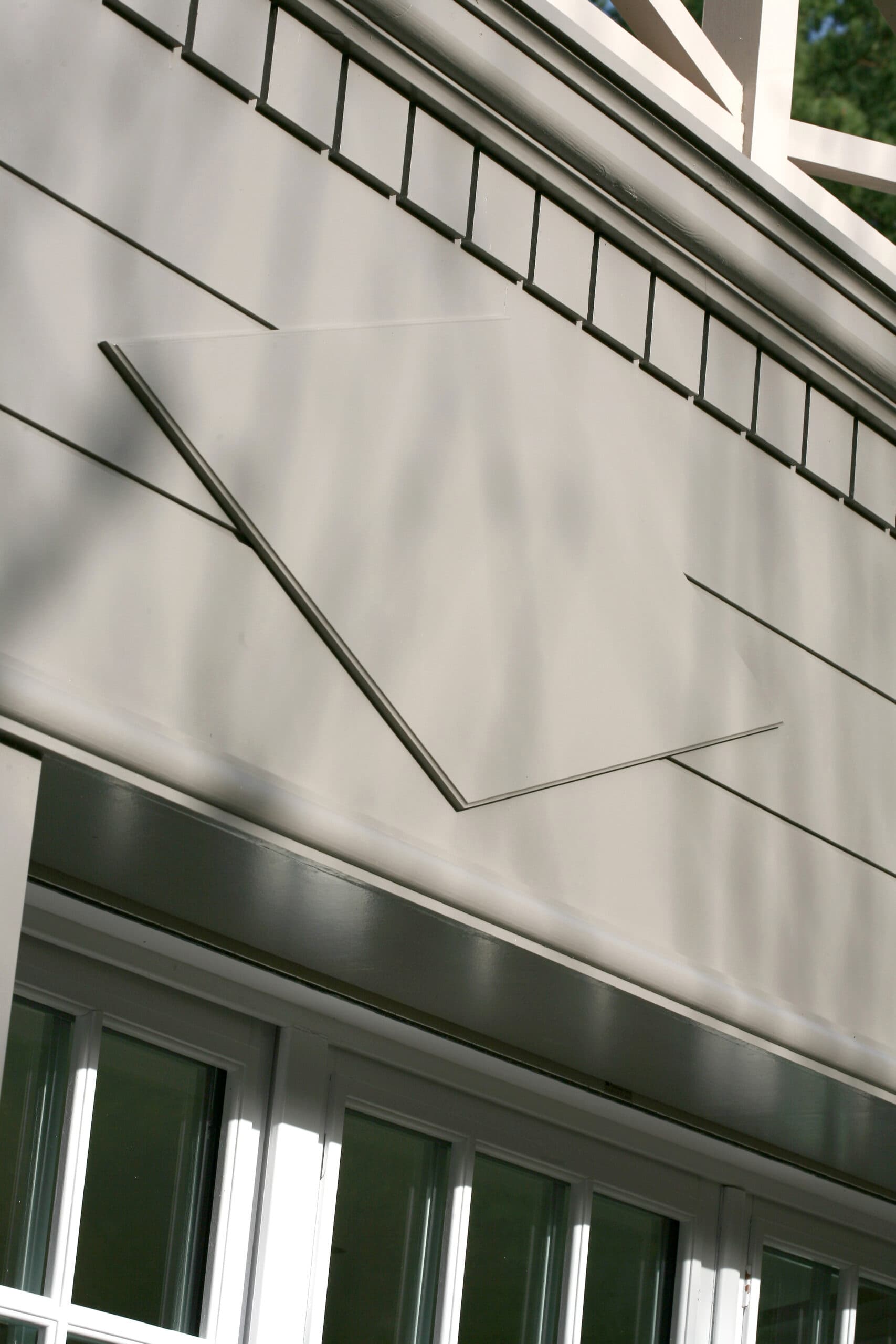 Détail d'un bardage en panneaux gris avec motifs en relief