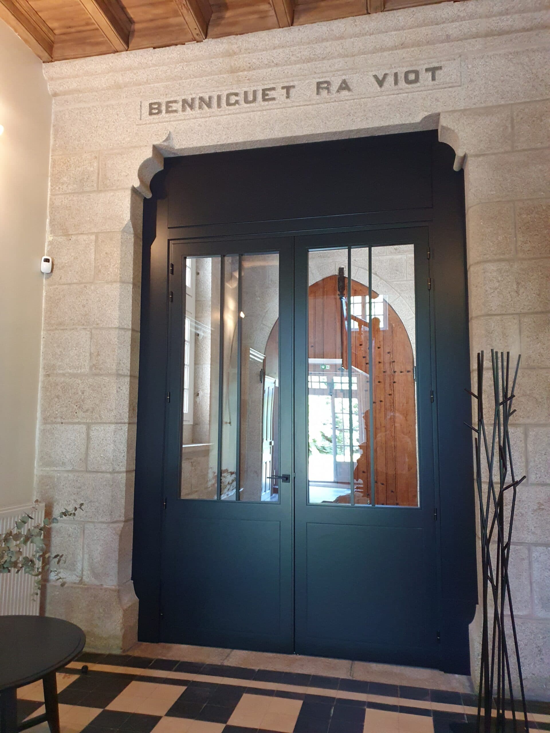 Porte d'entrée noire à vitrage en pierre de taille