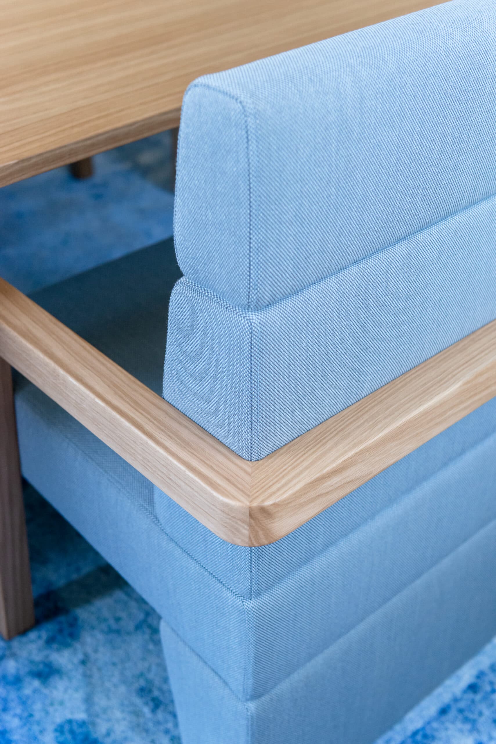 Détail d'une banquette en tissu bleu à structure chêne