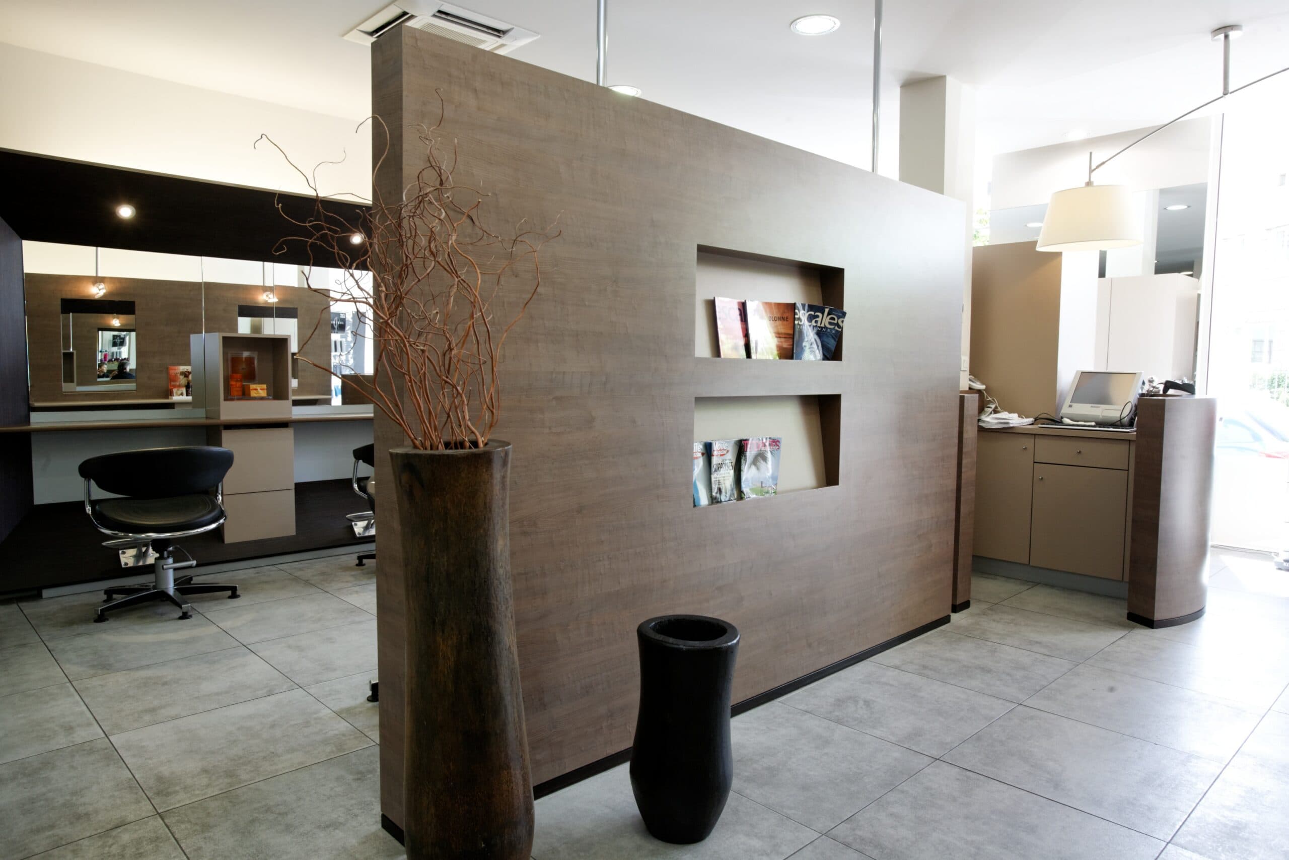 Cloison en bois avec niches de présentation dans un salon de coiffure