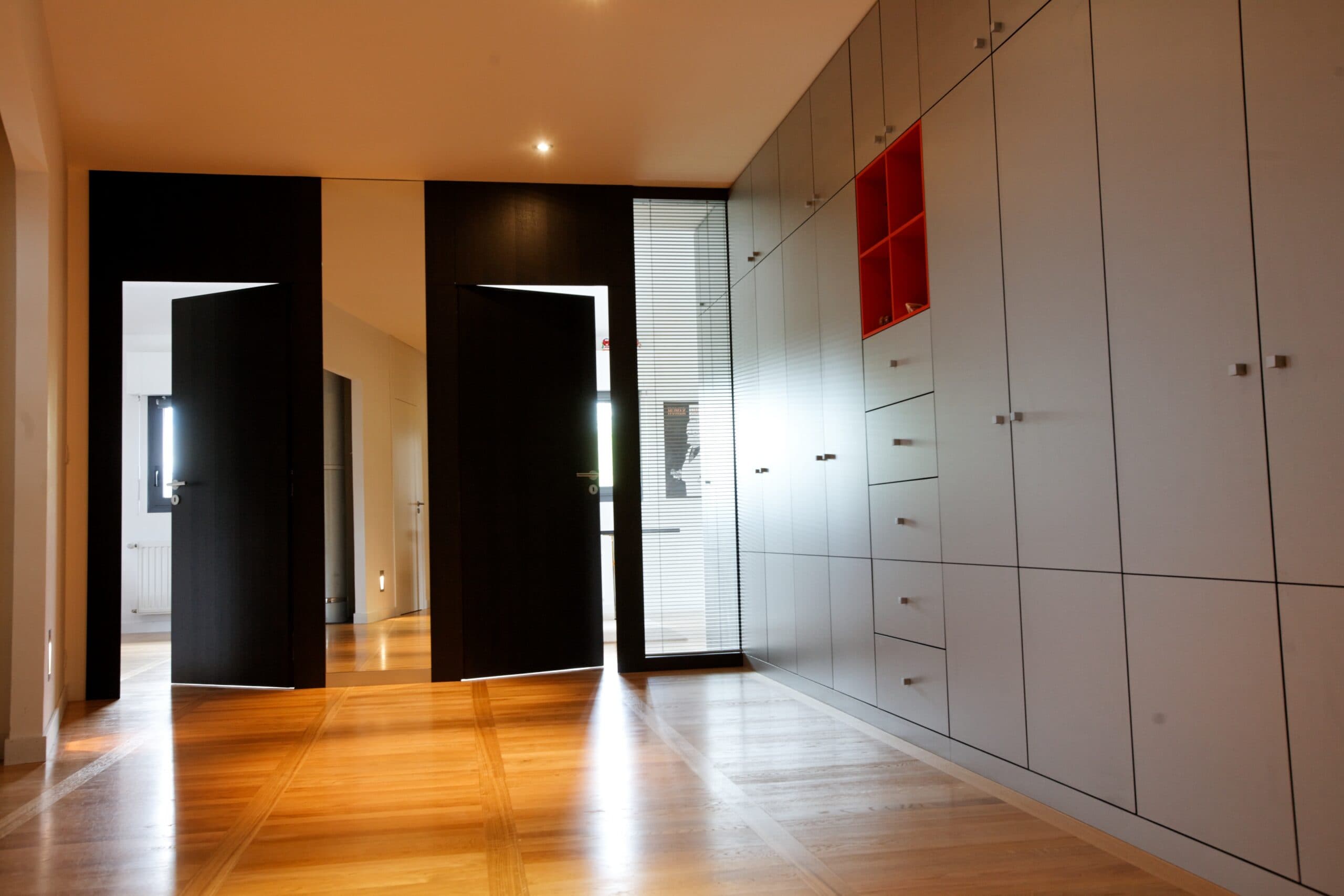 Hall avec placards muraux en bois clair et portes noires