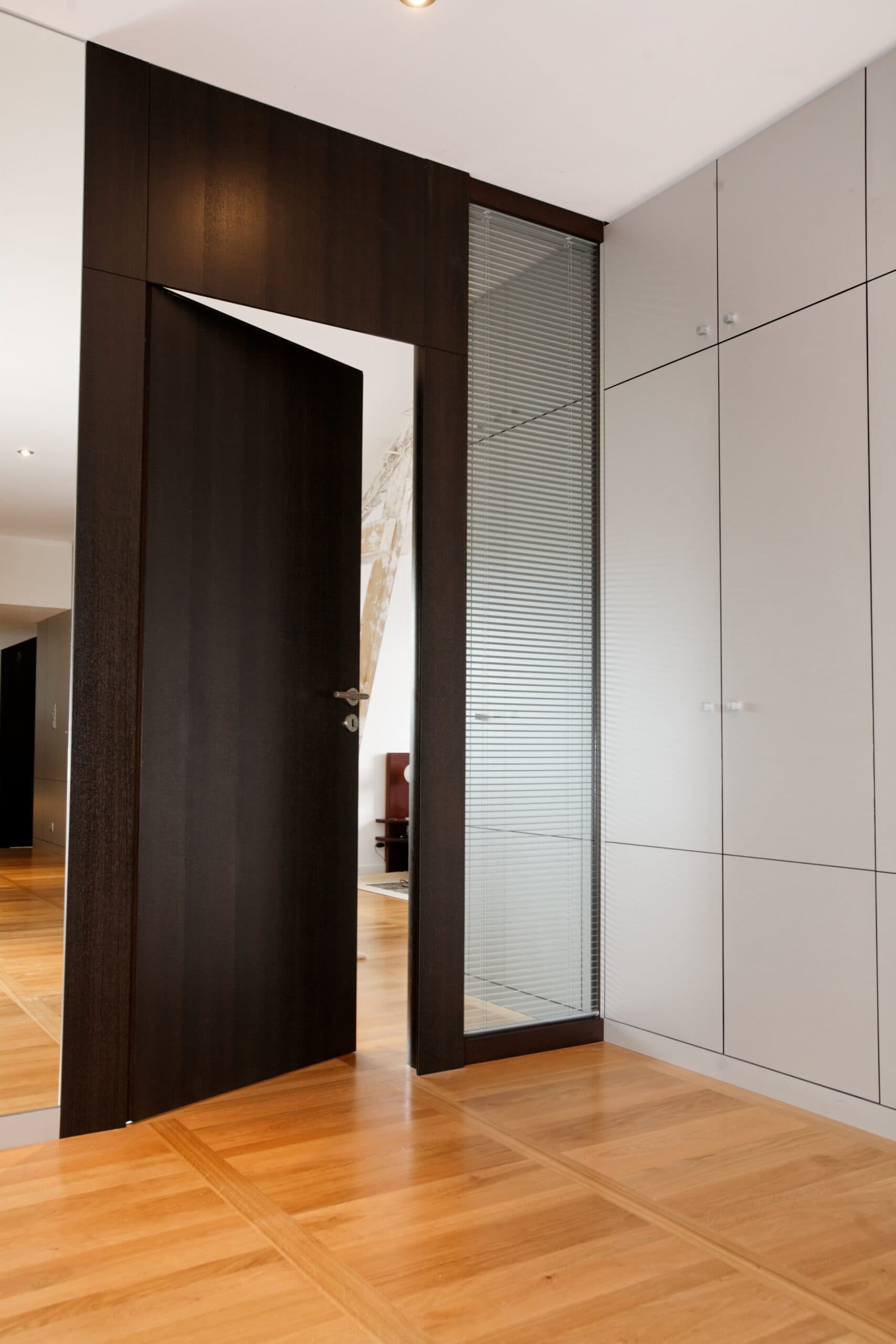 Porte en bois foncé entrouverte sur un dressing
