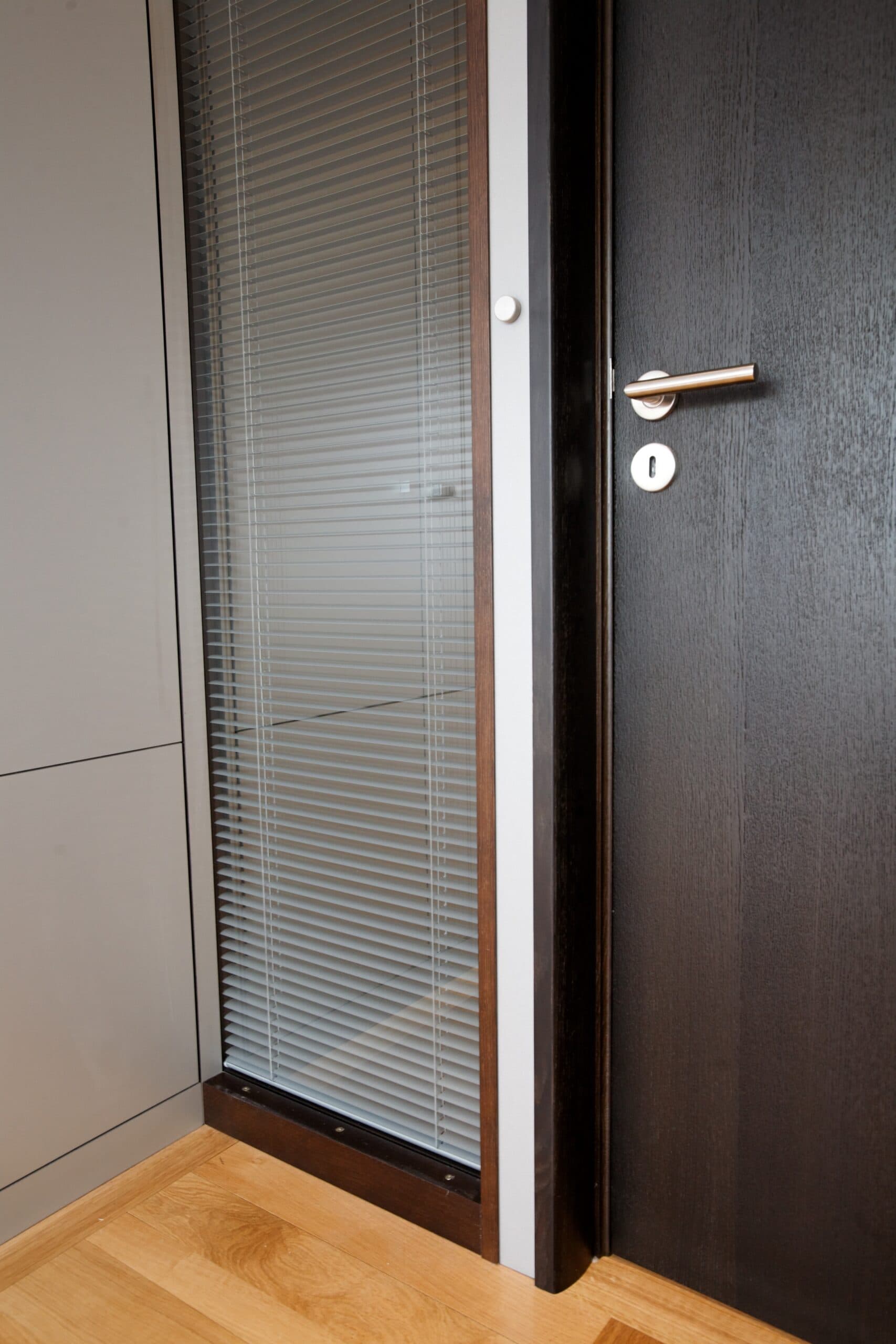 Porte en bois foncé à côté d'un placard gris