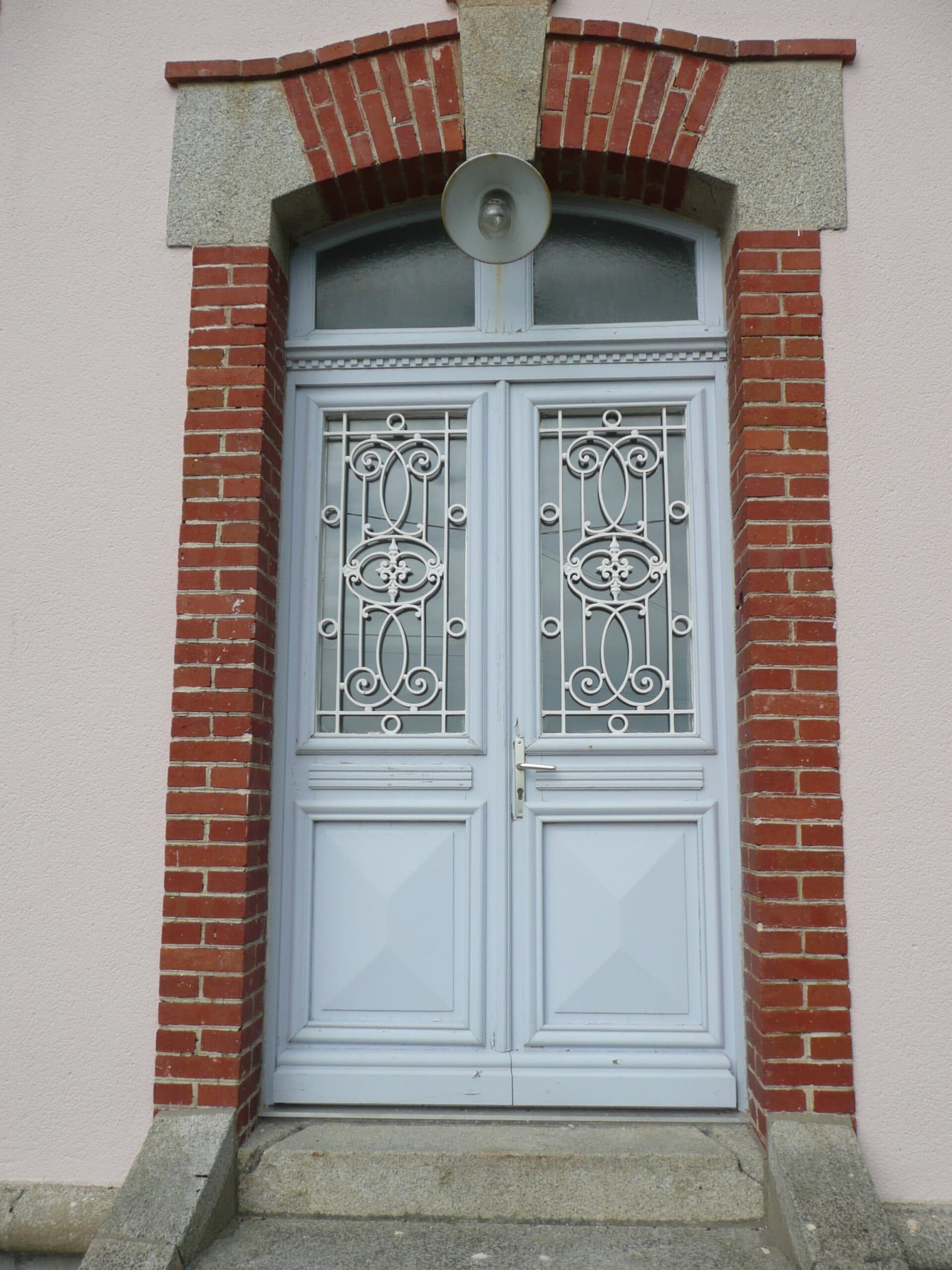Porte d'entrée claire encadrée de briques rouges