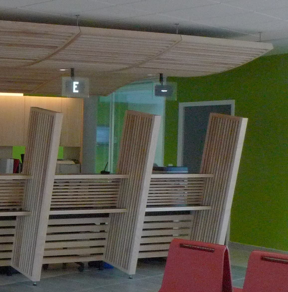 Habillage en lattes de bois et plafond suspendu dans un espace d'accueil