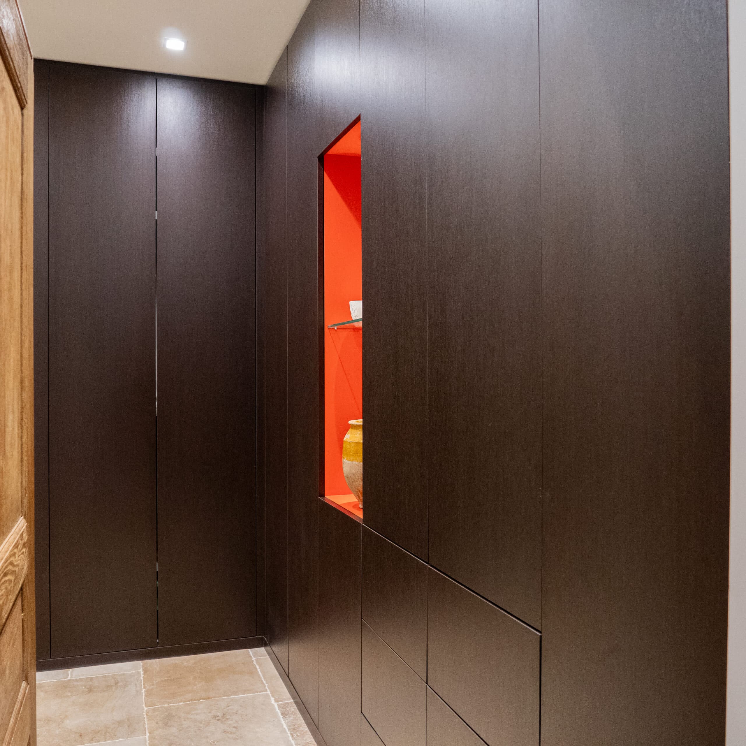 Placard coulissant en bois foncé avec niche rouge éclairée