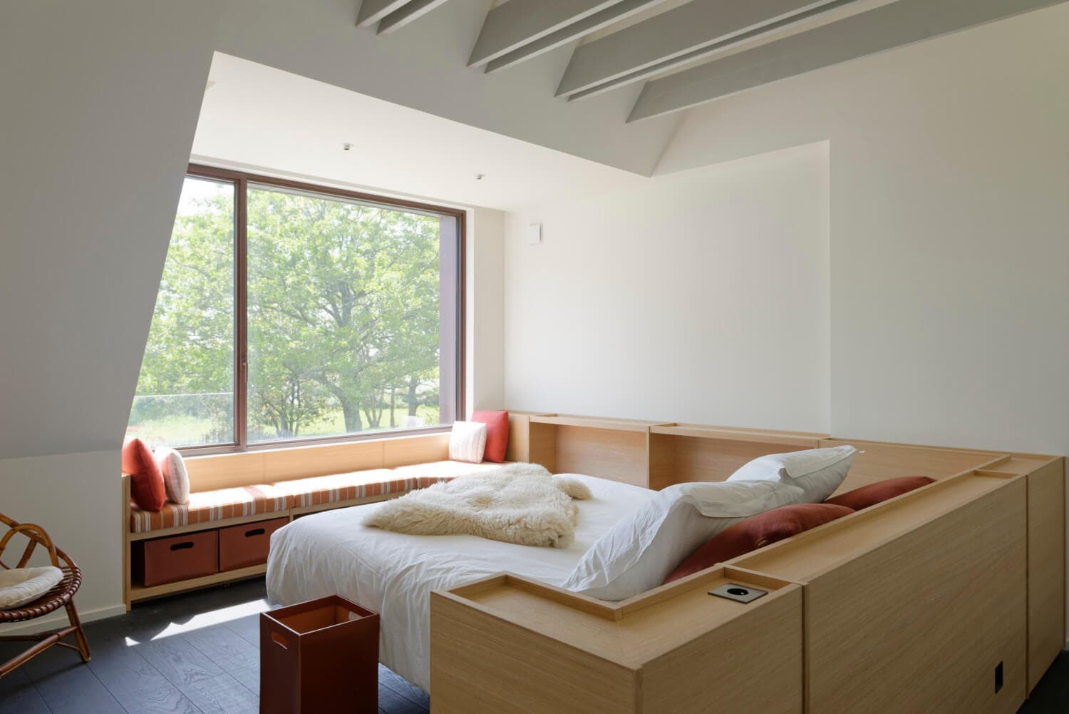 Lit sur mesure intégré à un meuble en bois sous une fenêtre