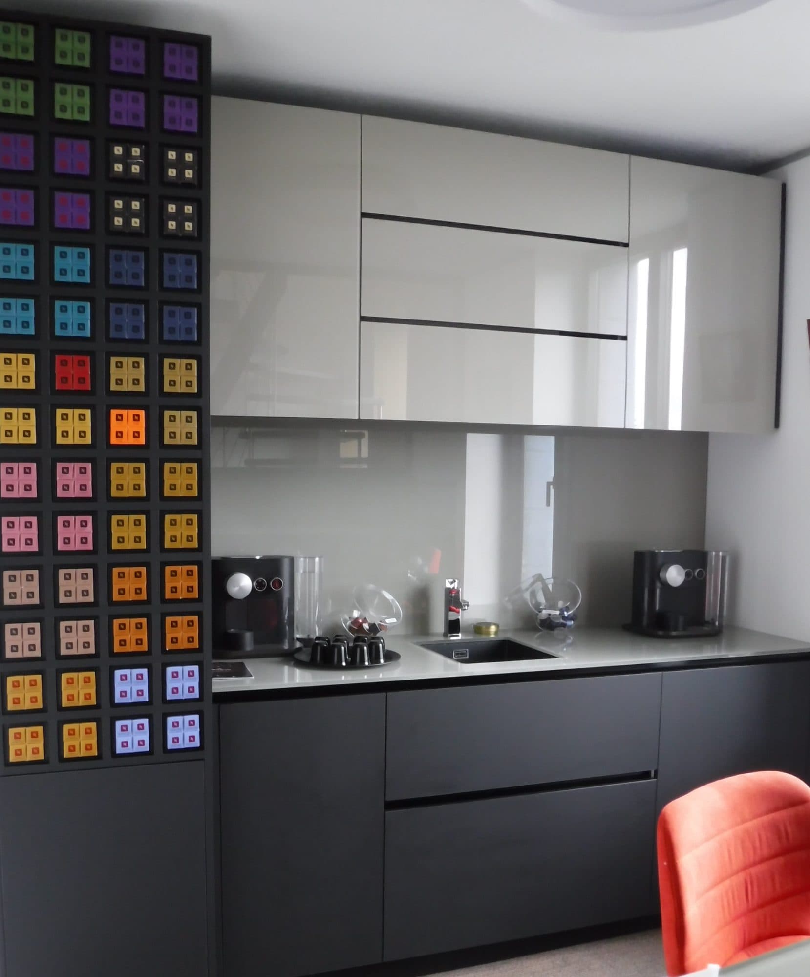Cuisine noire et blanche avec panneau mural coloré