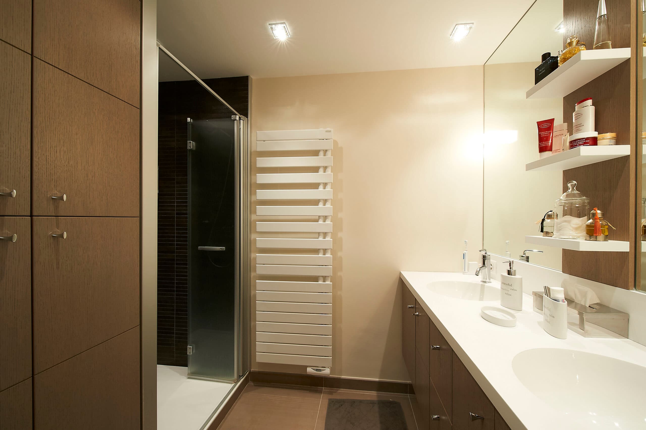 Salle de bain avec double vasque, sèche-serviettes et rangements