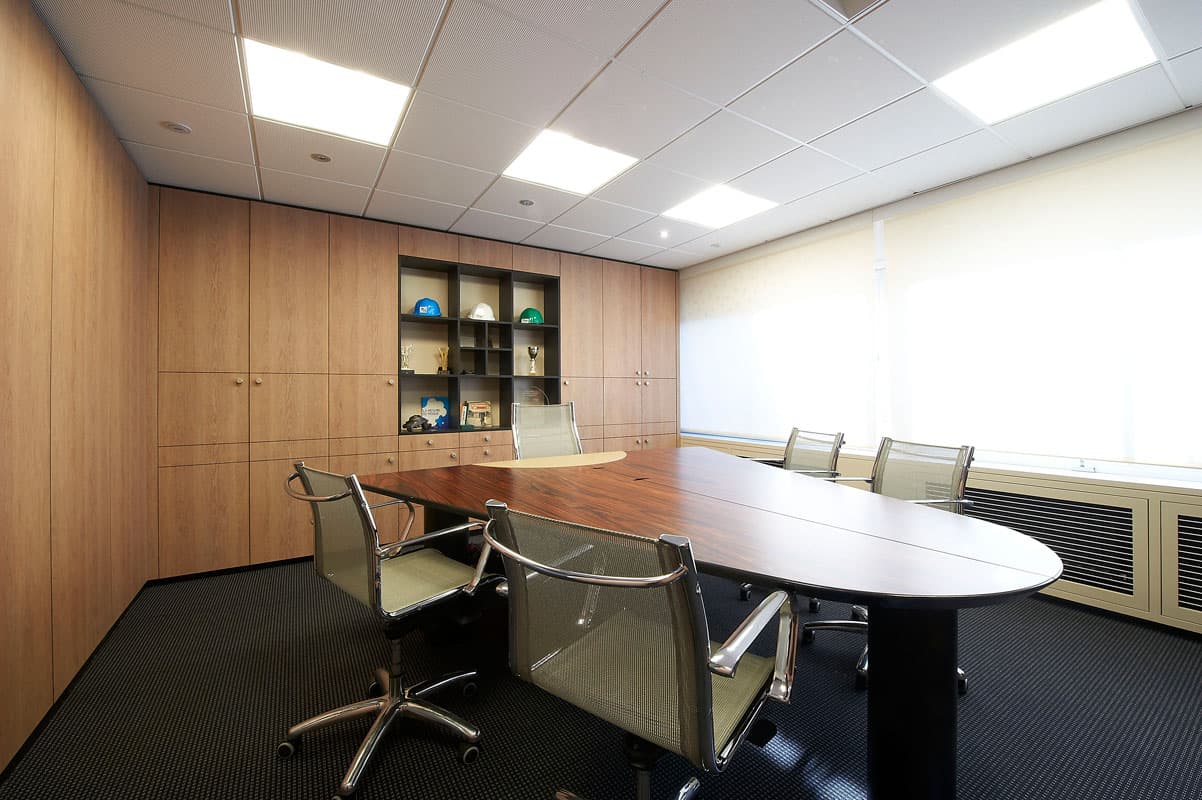Salle de réunion avec murs habillés de bois et table ovale