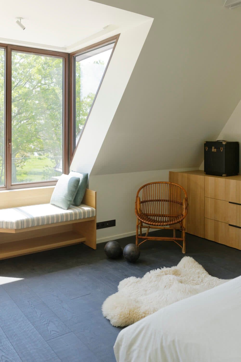 Chambre avec banquette sous fenêtre et meuble en bois