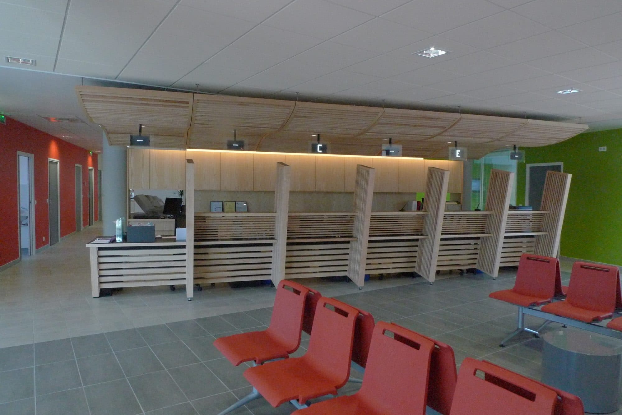 Hall d'accueil avec banque en bois et sièges rouges