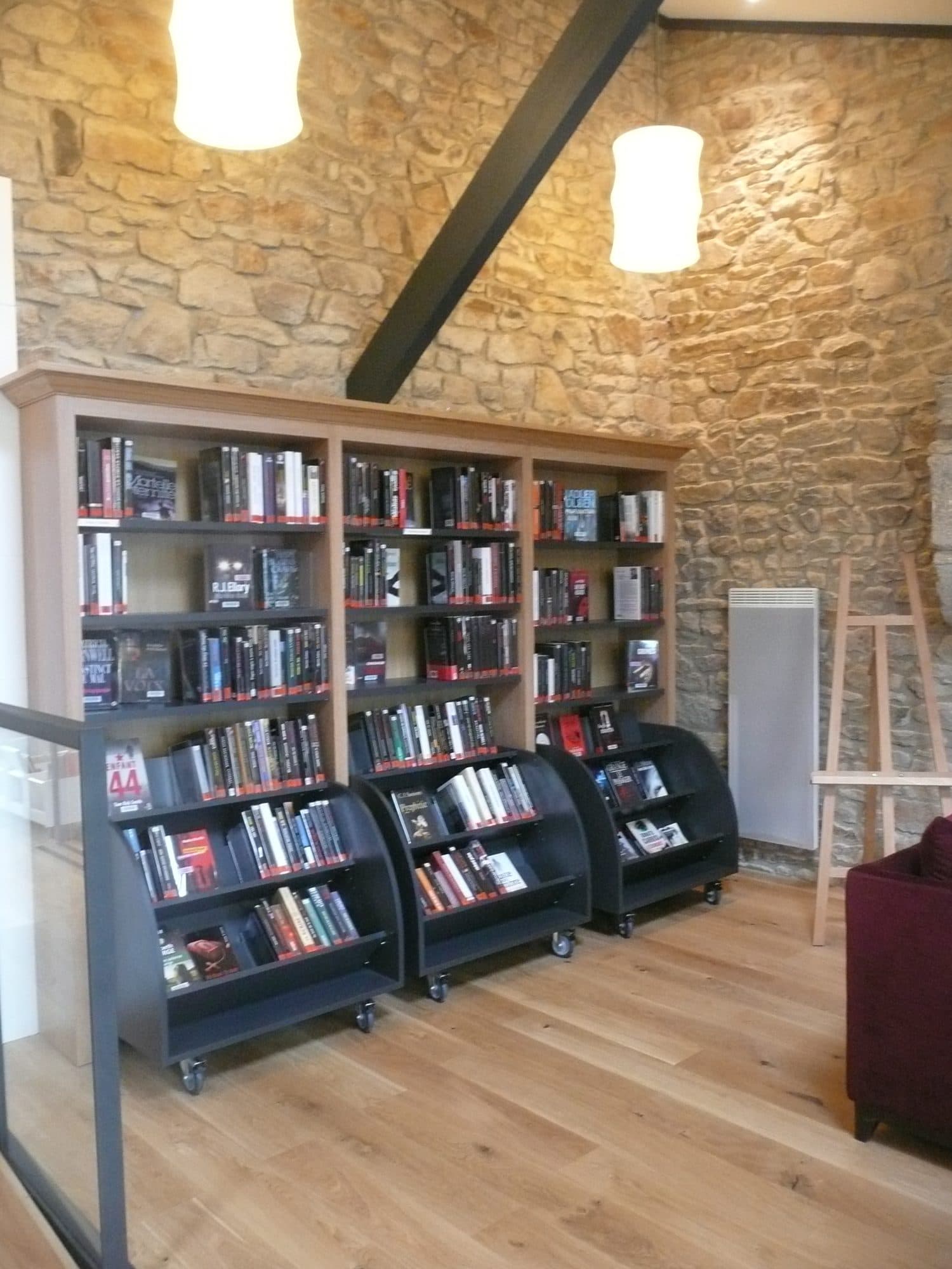 Rayonnages de bibliothèque en bois contre un mur en pierre