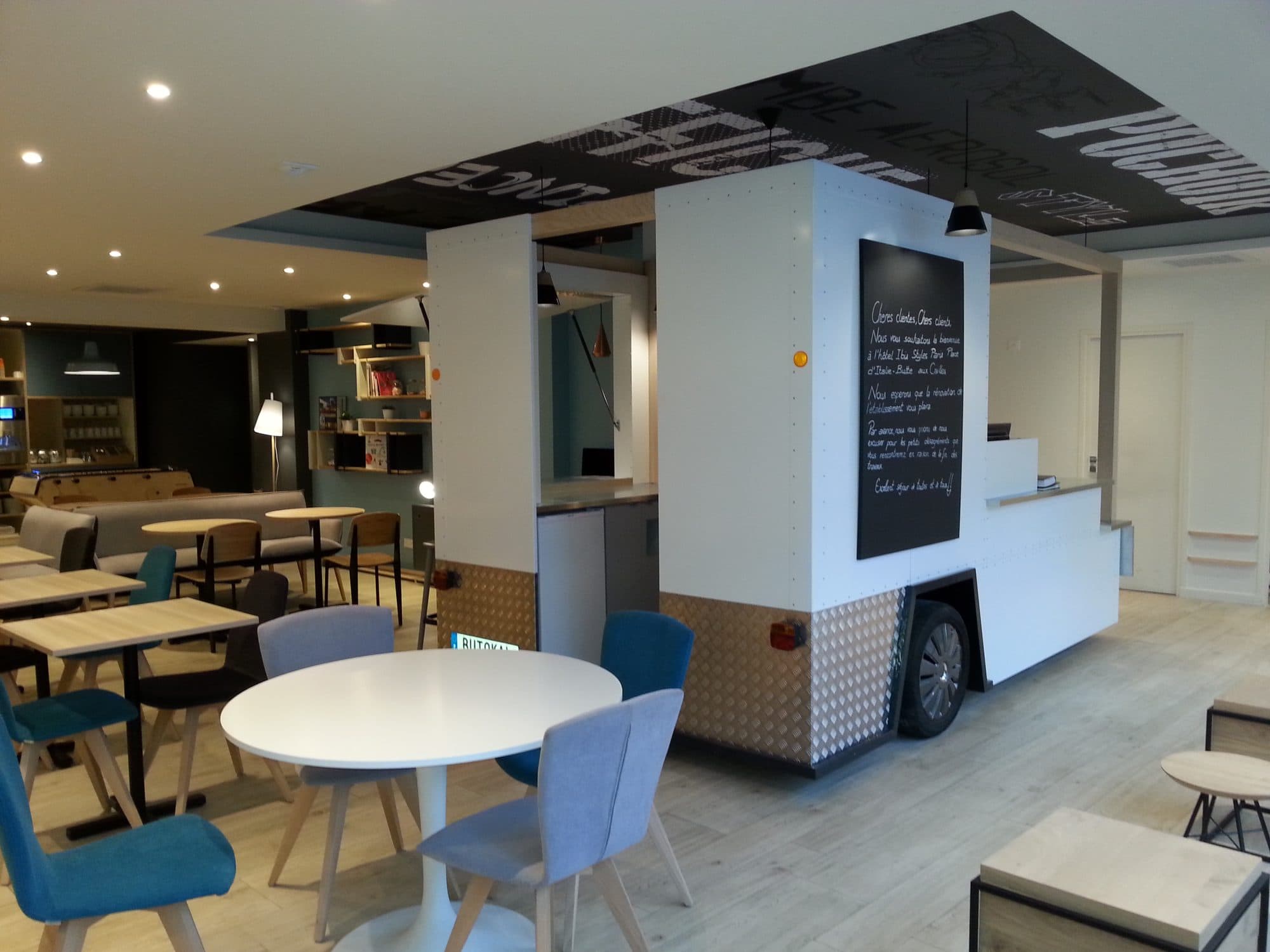 Salle de restaurant d'hôtel avec comptoir et tables rondes
