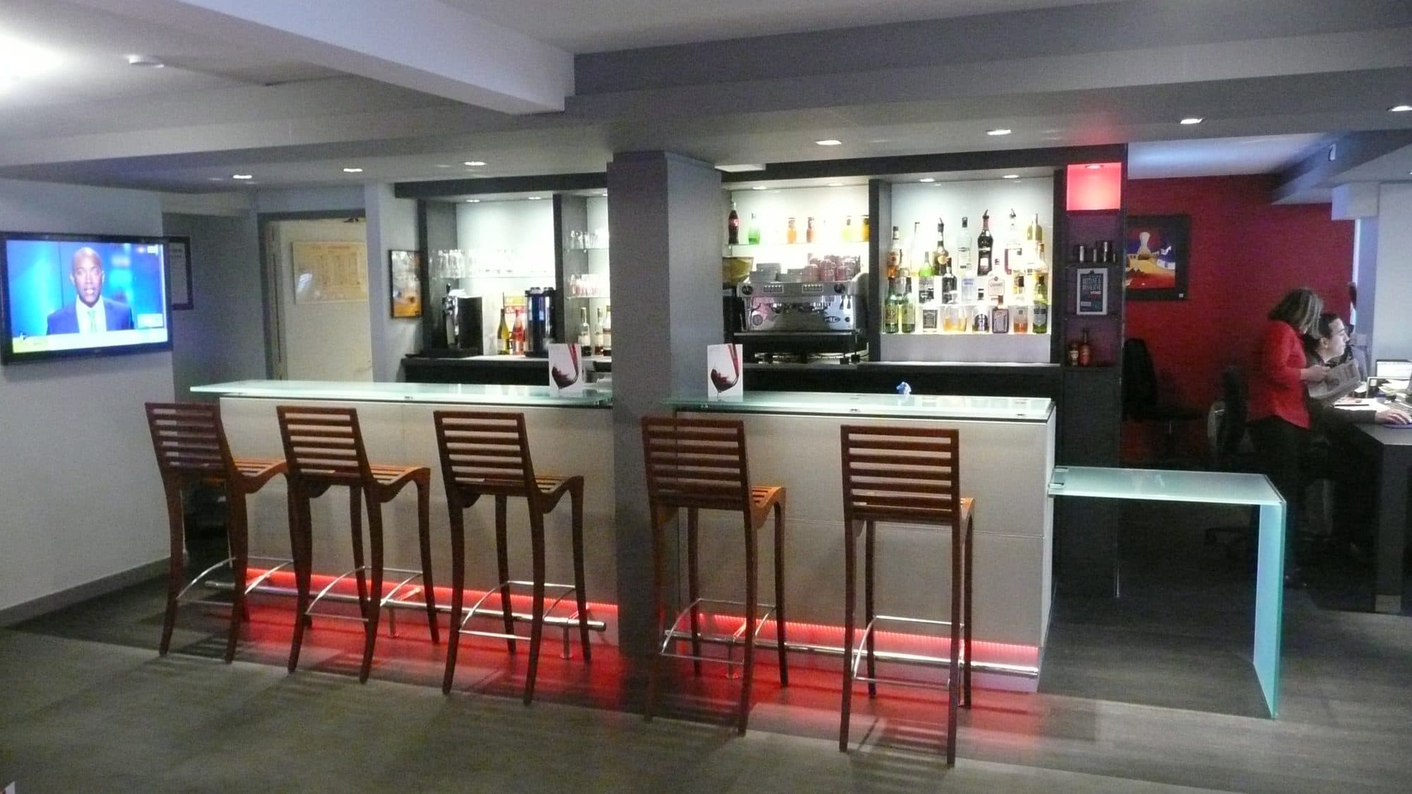 Bar d'hôtel avec tabourets et éclairage rouge au sol