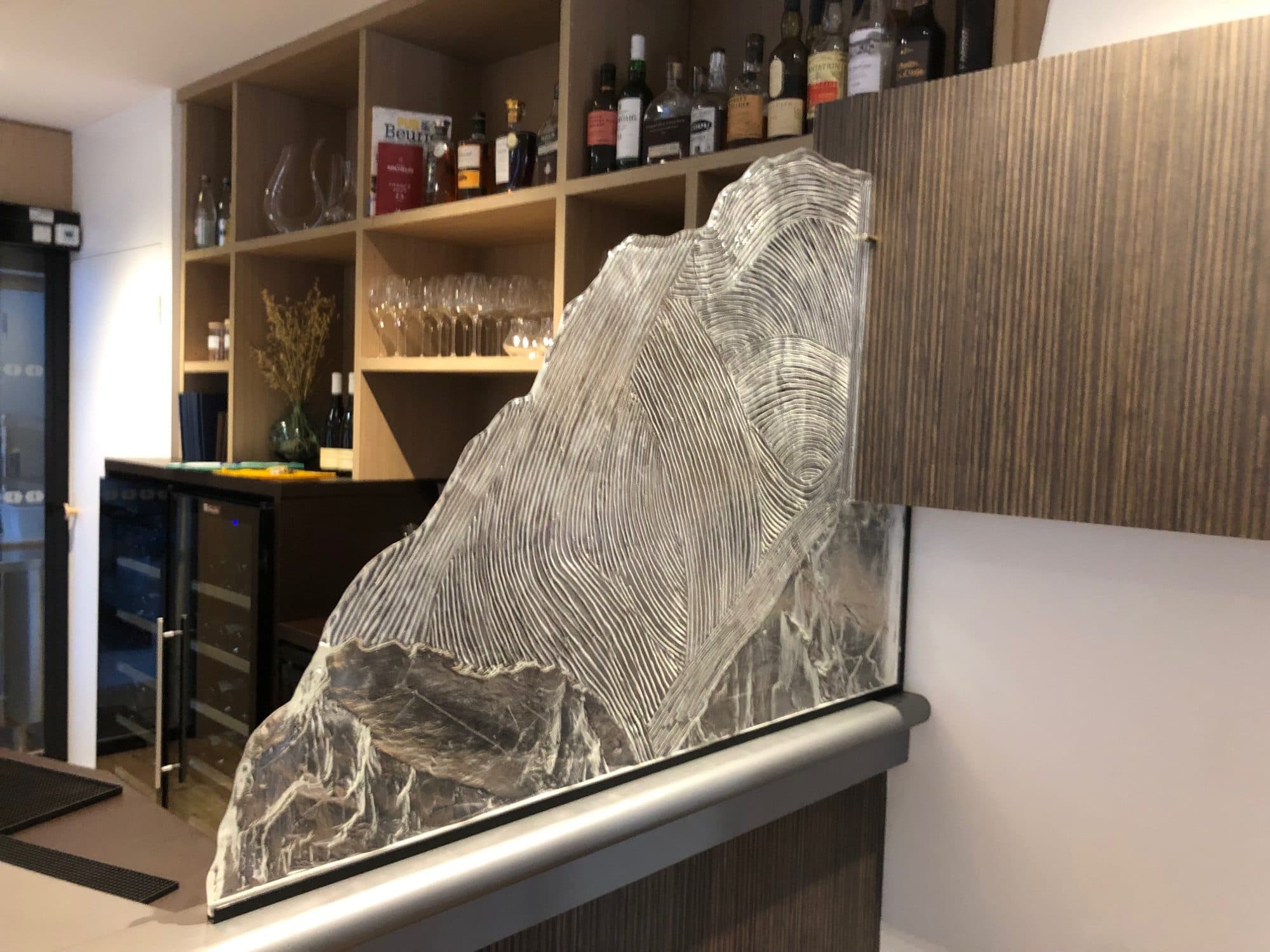 Bar avec sculpture en verre et étagères à bouteilles