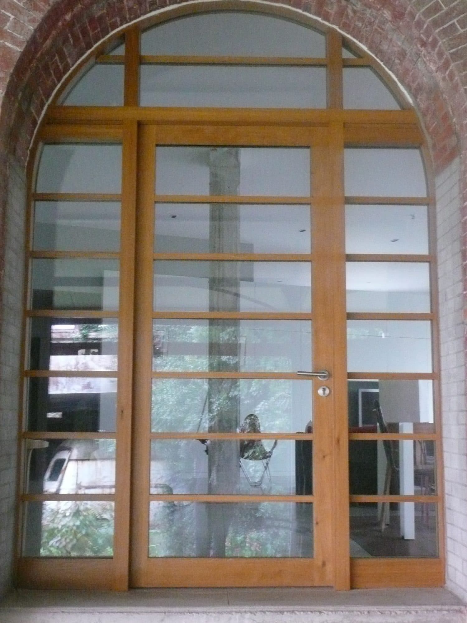 Porte d'entrée cintrée en bois à petits carreaux