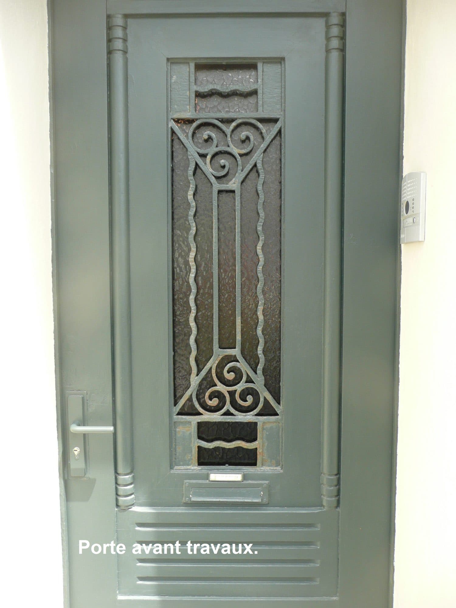 Porte d'entrée grise avec grille en fer forgé