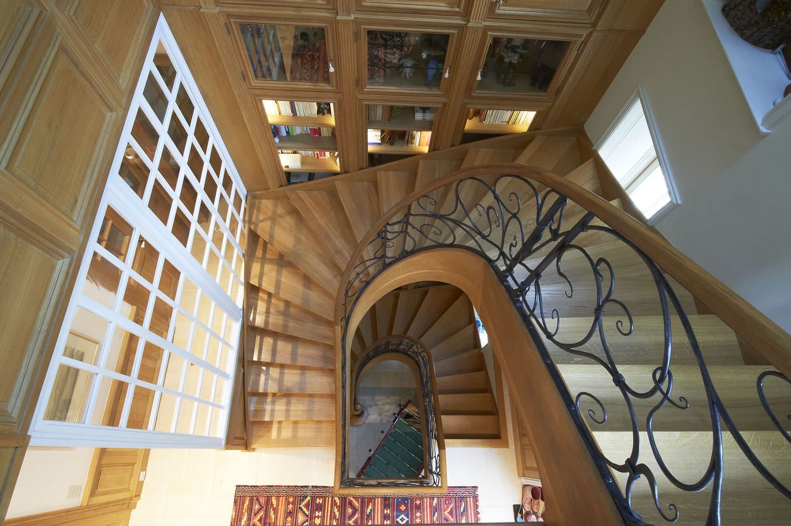 Escalier hélicoïdal en bois vu d'en haut avec rampe en fer forgé