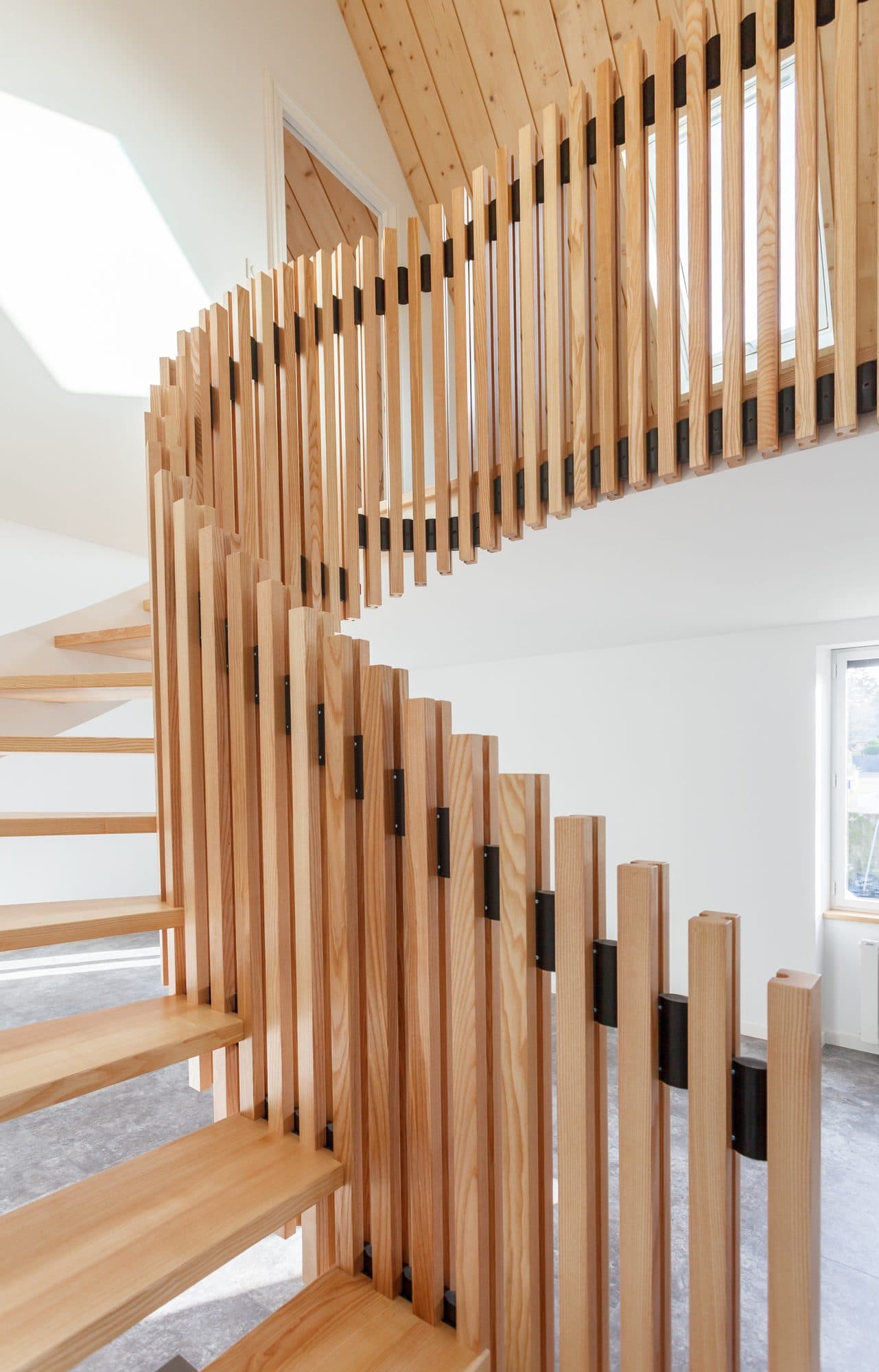 Escalier courbe en bois avec garde-corps à barreaux