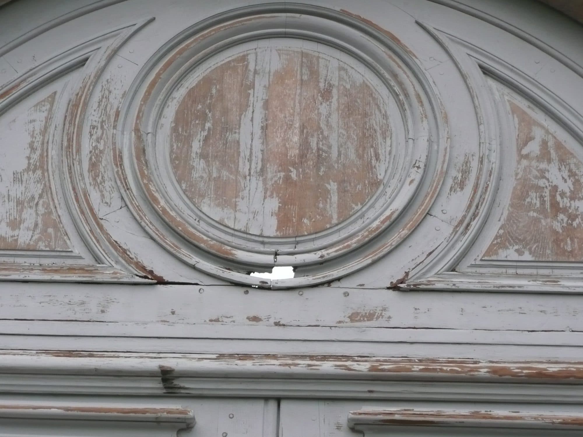 Médaillon sculpté d'une porte ancienne avant restauration
