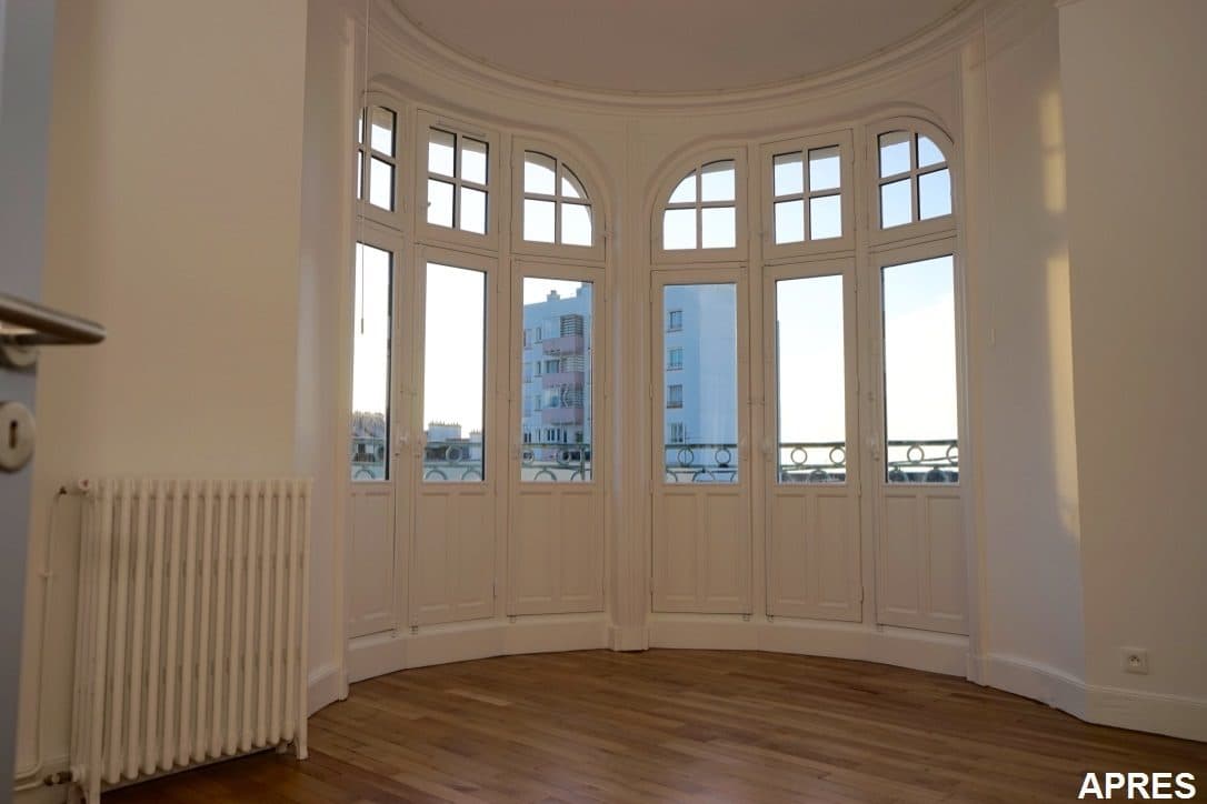 Bow-window restauré avec fenêtres en bois blanches