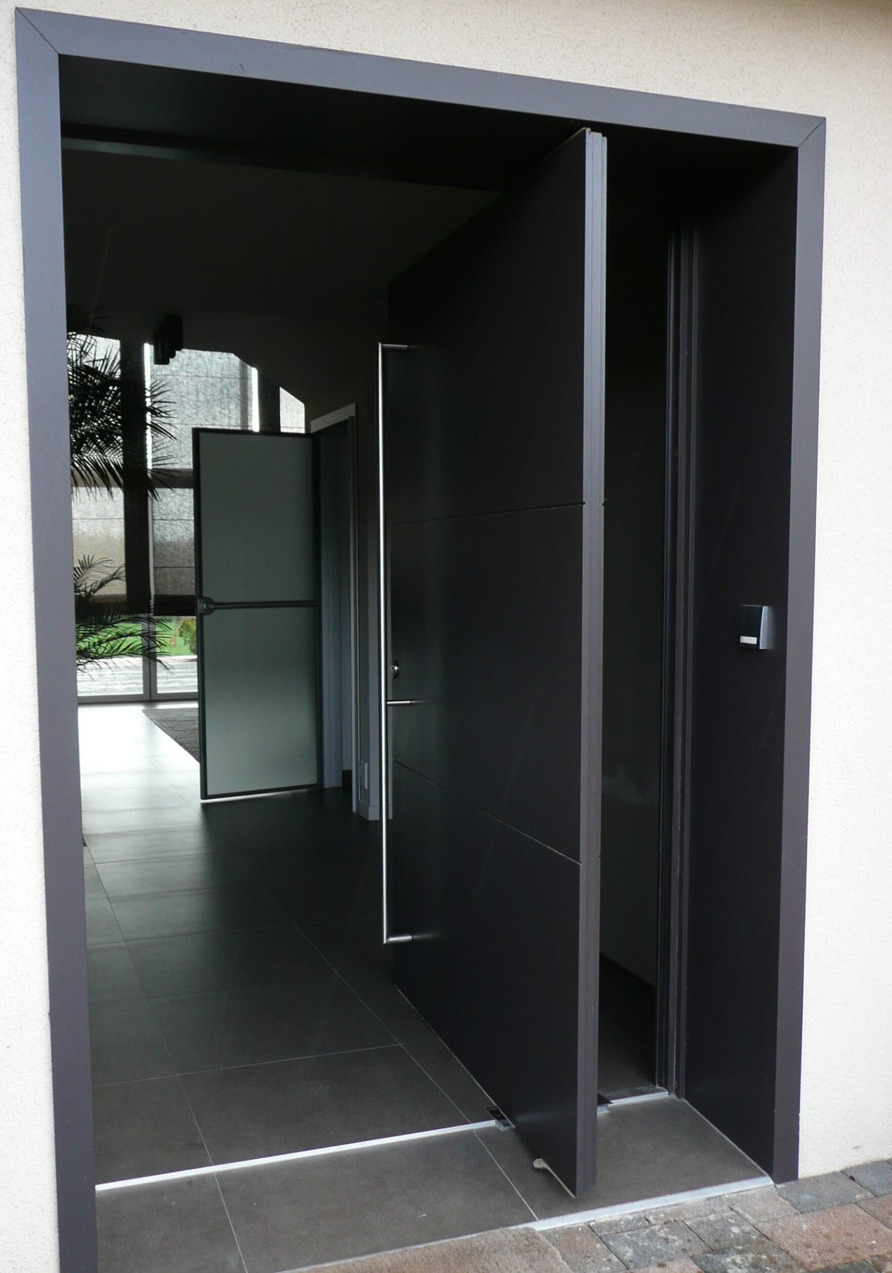Porte d'entrée anthracite ouverte sur un hall
