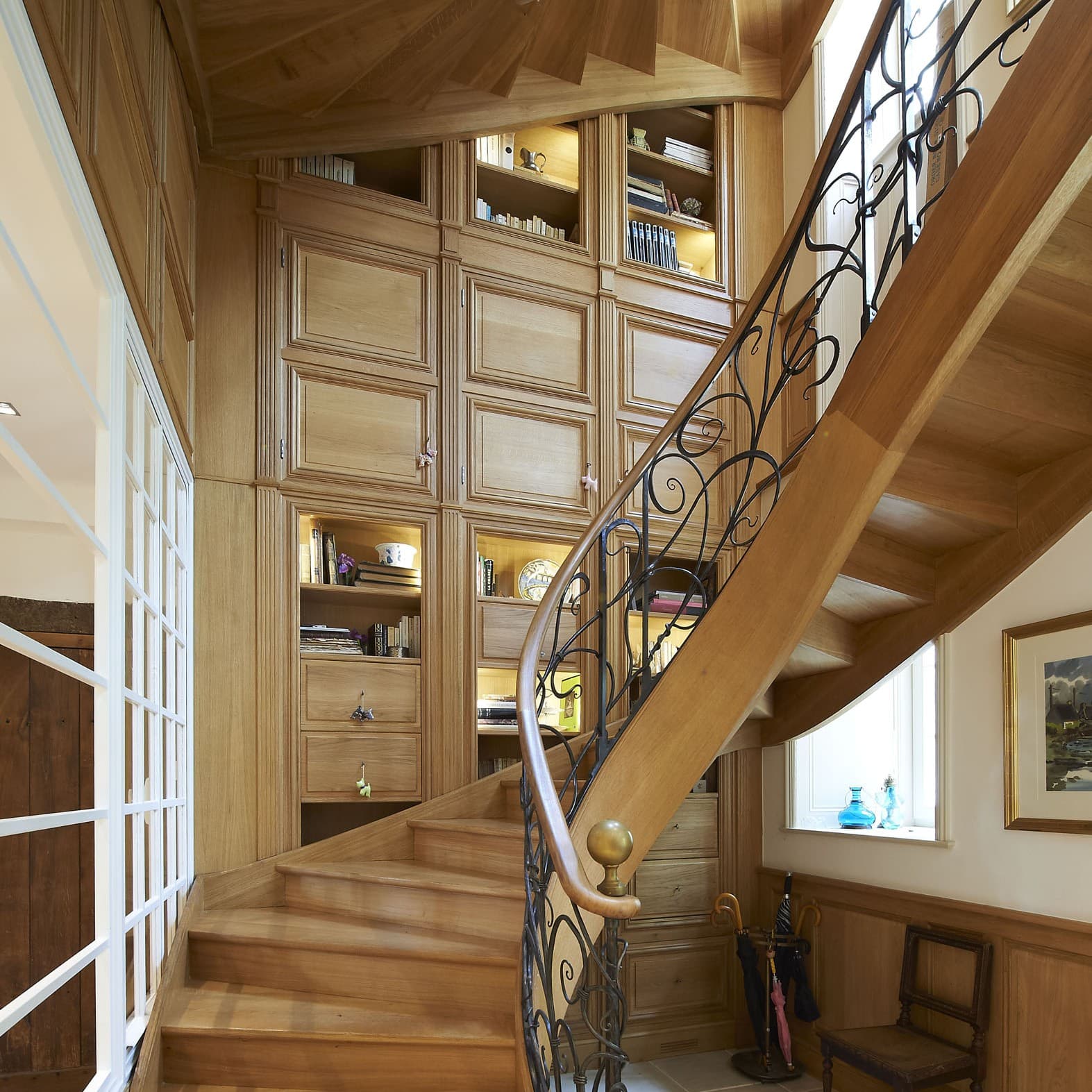Escalier en bois et rampe en fer forgé avec bibliothèque